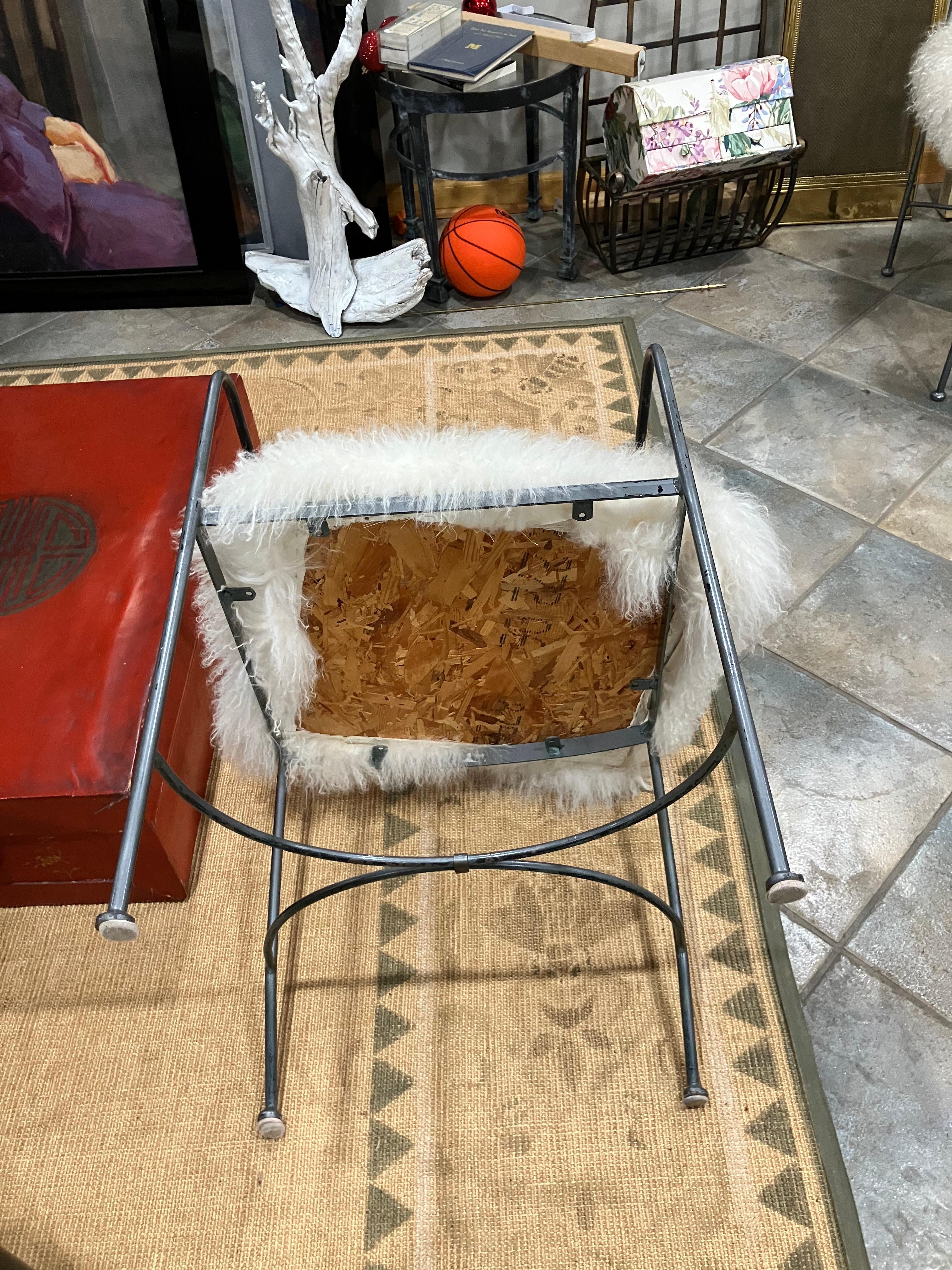 Set of four American metal chairs dating to the 1980s. Each chair features a four-legged base with a streamlined, contemporary metal backrest. The set includes custom slipcovers made from real sheepskin, tailored specifically to fit this design. The