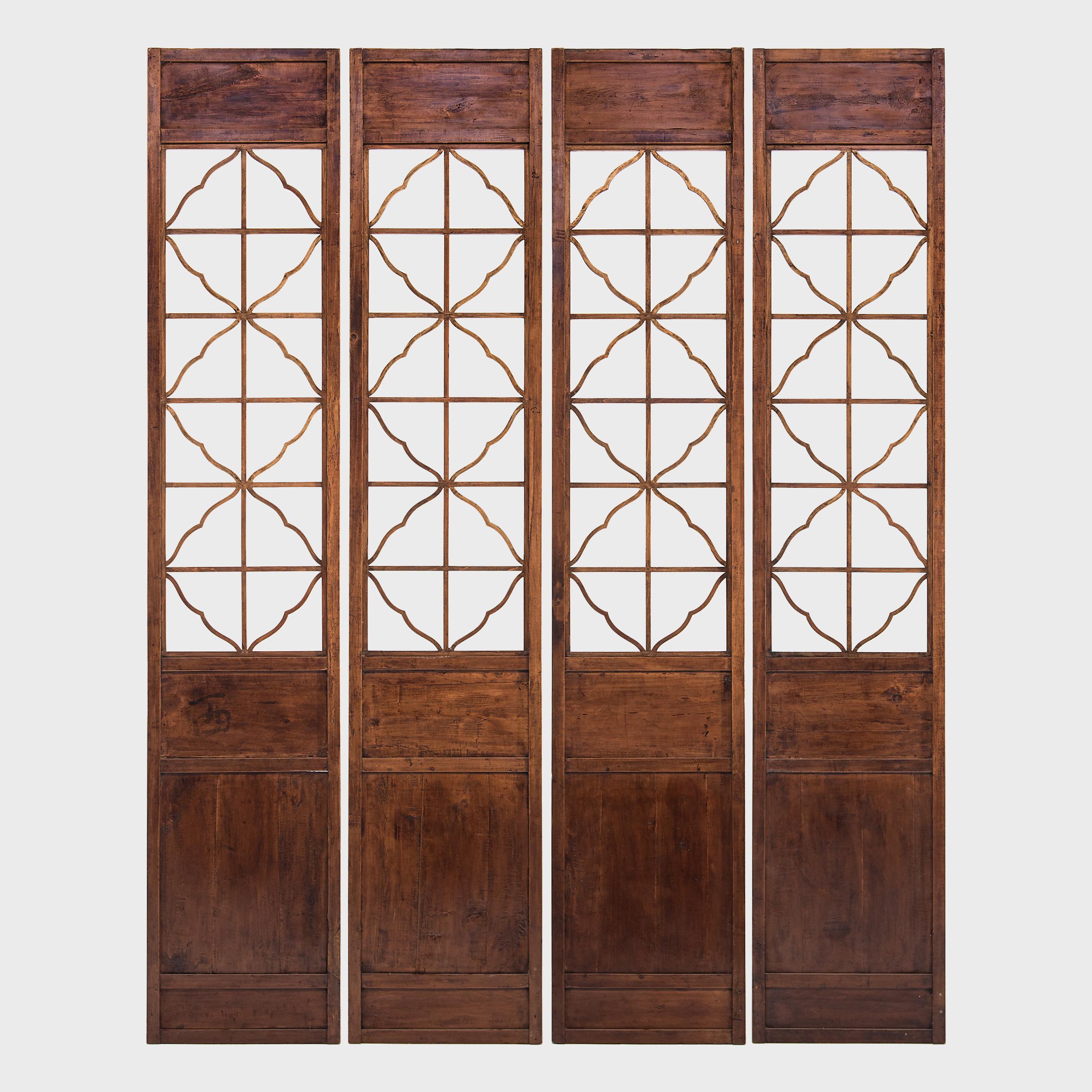 The grand height and exquisite decorations make this set of four 19th century lattice panels a truly rare find. Likely the once courtyard doors of a fine Qing dynasty home in southern China, these tall panels were crafted with light and open