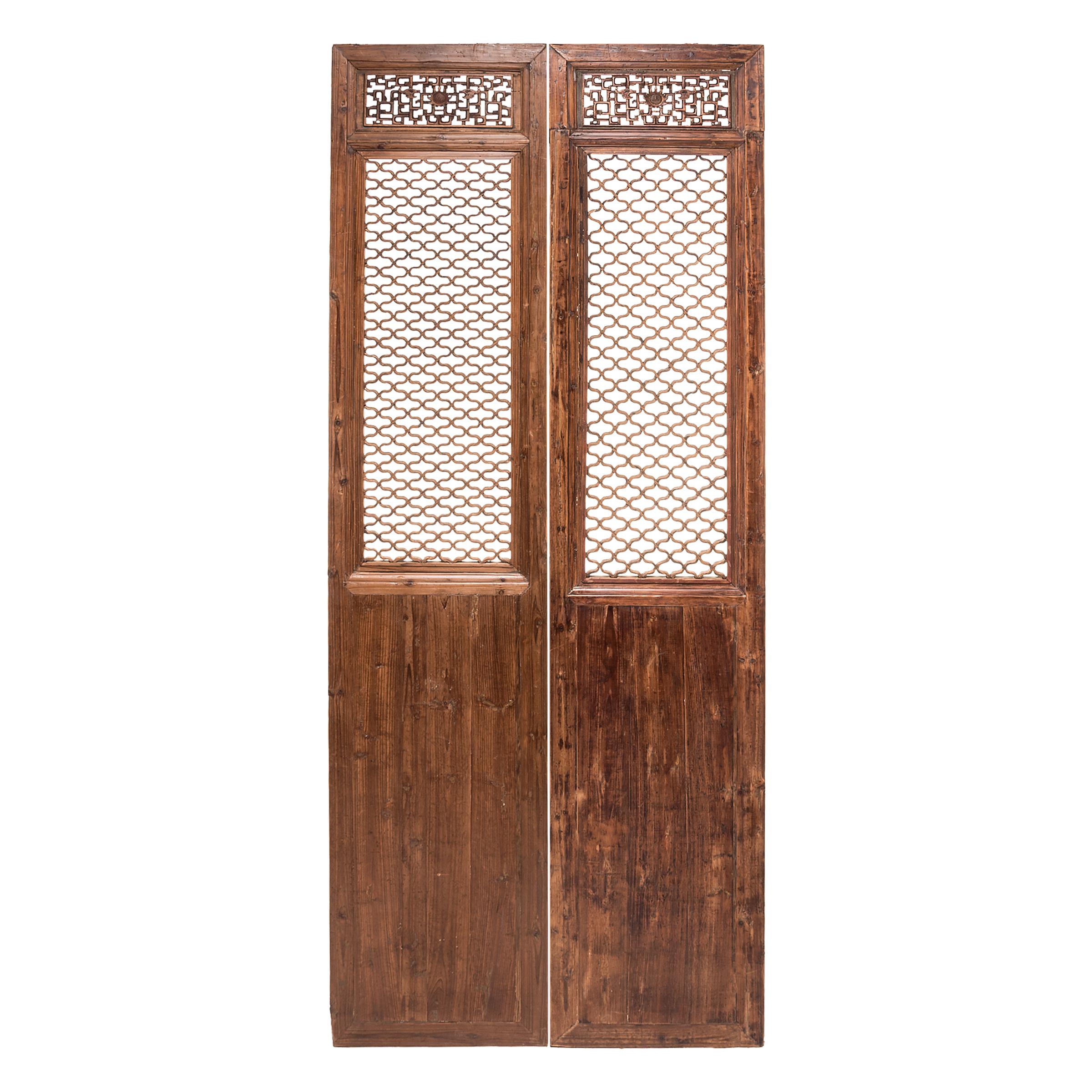 The sweeping elegance of these four 19th century courtyard doors, with their intricate lattice panels, hides the mathematical brilliance required to create them. The wax-finished, knotty panels evoke life in a traditional courtyard home, where the