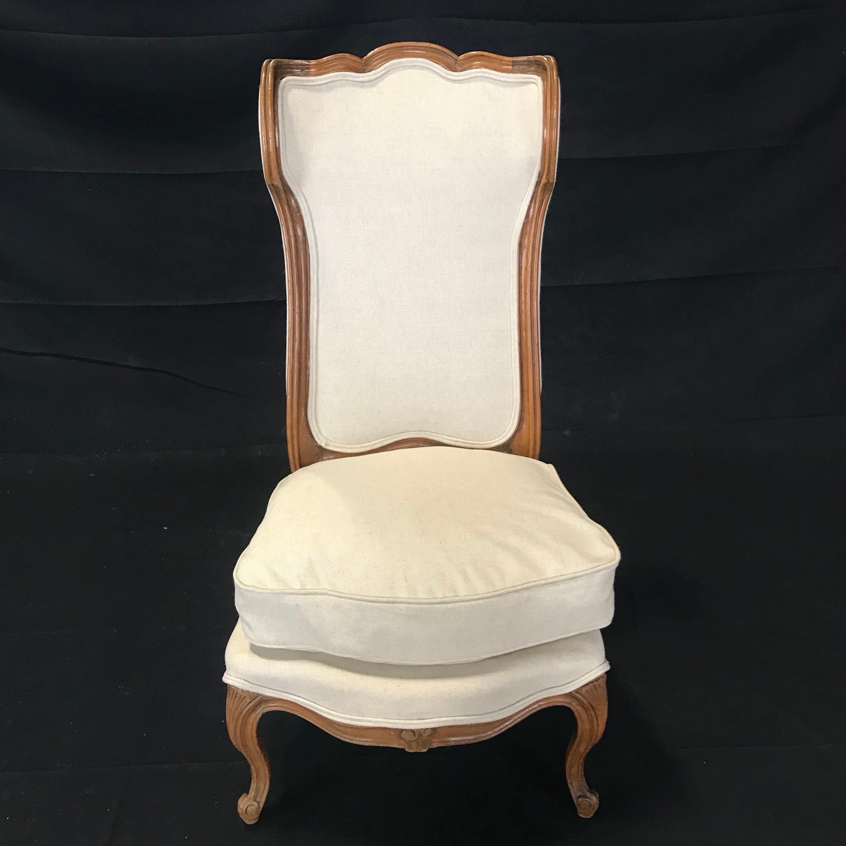 Set of 4 French Louis XVI style circa 1870 wingback bergères having refined carved walnut frames that compliment the new British linen cotton blend neutral high end upholstery. Cushions retain the original down fill. The sides, meant to provide both