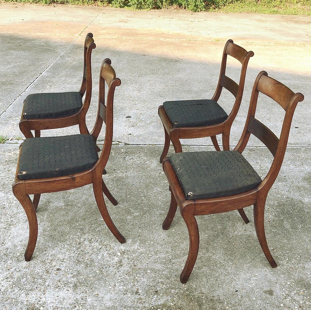 Set of four 19th century English mahogany chairs features an elegant look inspired by the French Empire style, with the sheer natural beauty of the exotic imported mahogany showing forth in the framework around the generously appointed seat. The