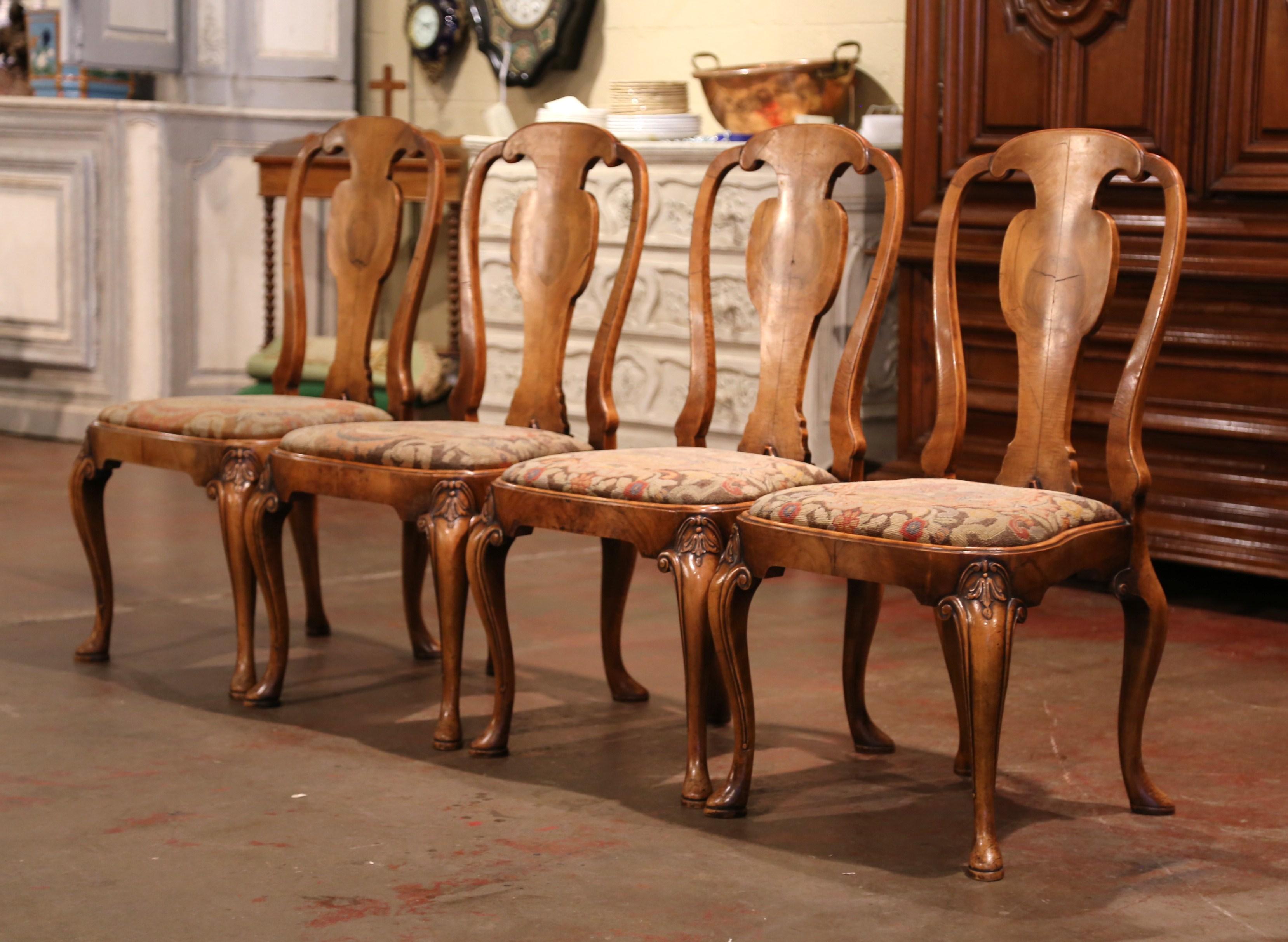 Decorate a game table or breakfast room with this elegant set of antique chairs; crafted in England circa 1880, each chair stands on cabriole legs decorated with leaf motifs at the shoulder. The seats are upholstered with handwoven needlepoint