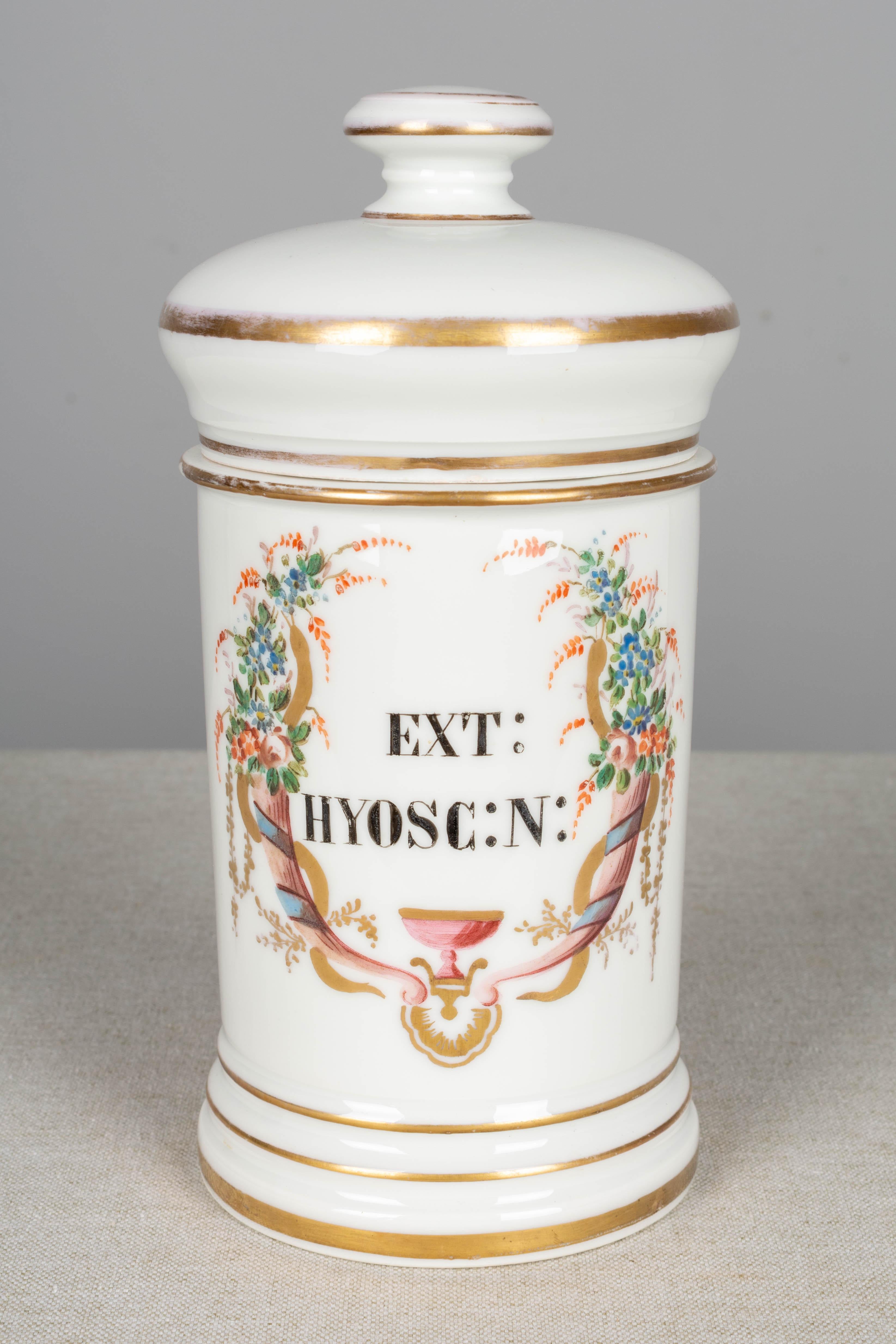 Ein Satz von vier französischen Apothekerdosen mit Deckel im Limoges-Stil aus dem 19. Jahrhundert mit elegantem, handgemaltem Blumendekor und Schriftzug. Ein Glas hat auf der Rückseite ein Apothekenetikett. Ein Teil der vergoldeten Farbe ist von den