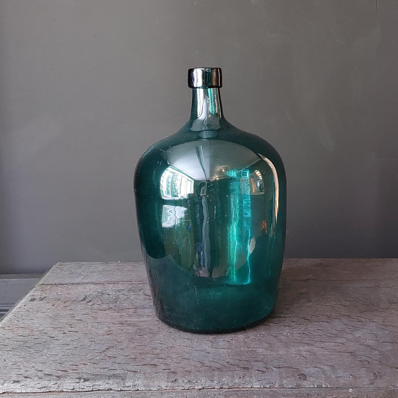 Set molto decorativo di 2 vecchie bottiglie in vetro soffiato verde-blu, note come Demijohn, Lady Jeanne o Carboy. Prodotto e utilizzato tra il 1880 e il 1920       

Queste vecchie bottiglie di vetro sono caratterizzate da bolle e lievi
