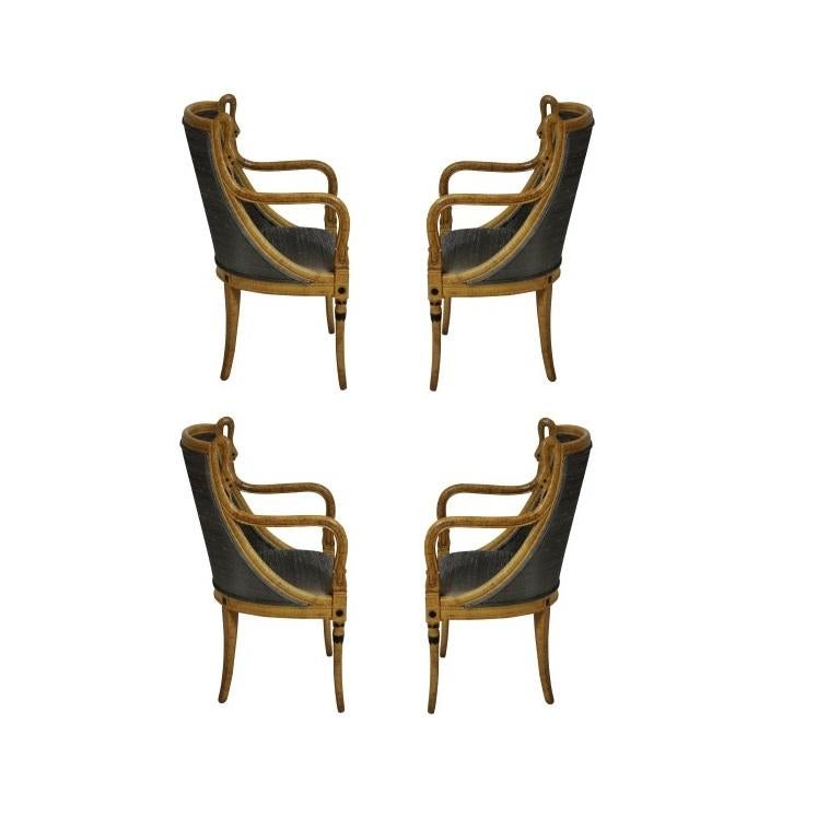 A charming set of four 19th century decorative dining chairs with French Empire influence. The handcrafted frames feature sweeping curved barrel backs being flanked by carved swan necks, drop in seats raised on turned and carved front legs and splay