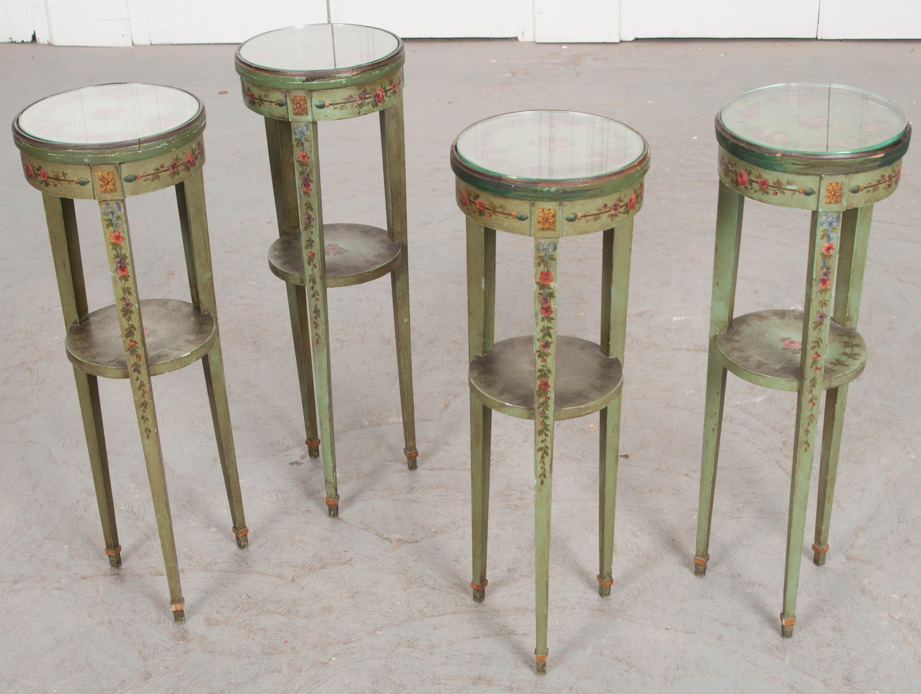 A cheerful set of four hand painted drink tables, with glass tops, from 19th century France. These friendly little tables provide wonderful places to place a drink while seated. Placed beside chairs or sofas, these wonderful little tables are great