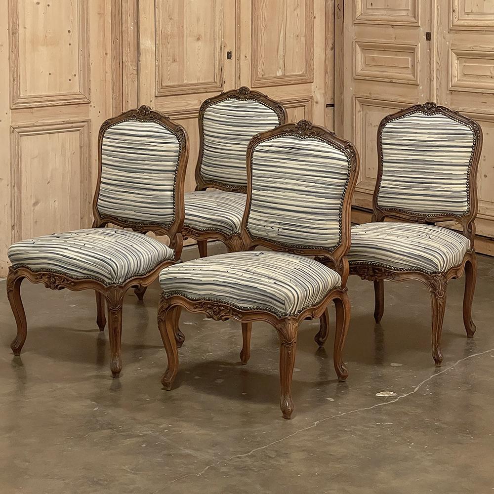 Set of Four 19th century French Louis XV fruitwood side chairs feature the classic form definitive of the Rococo style, with violin-shaped seat backs, generous seats, and an undulating apron supported by four cabriole legs. The crest of the seat