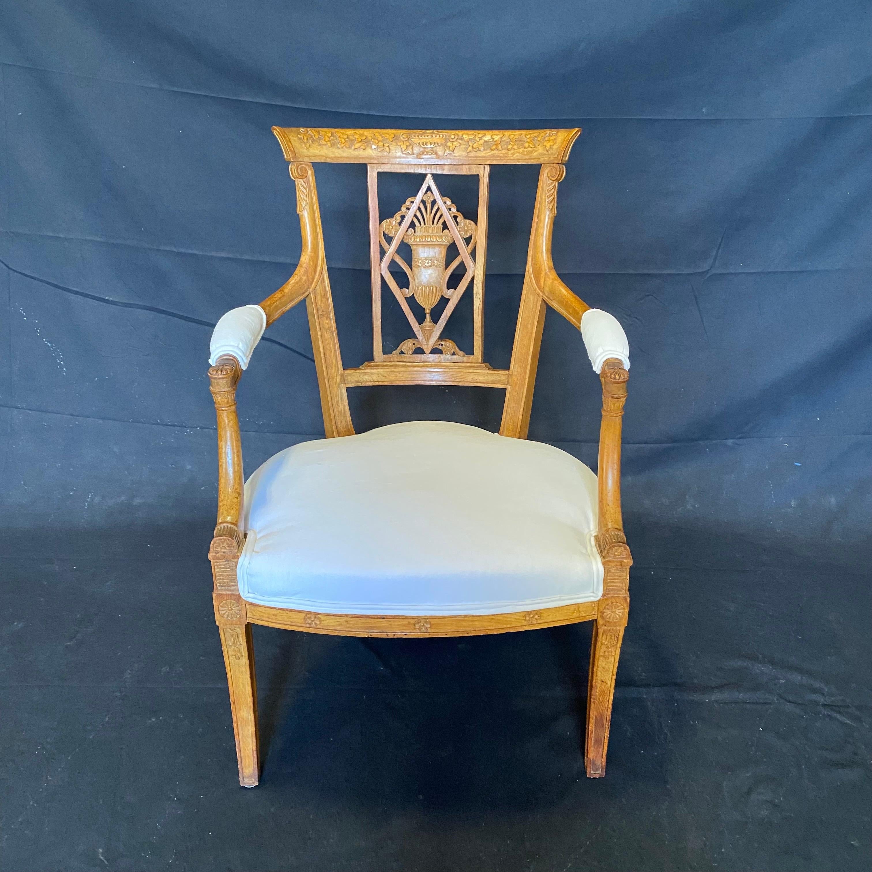 Ein klassischer Satz von vier französischen neoklassizistischen Nussbaumsesseln aus dem frühen 19. Jahrhundert, mit geschnitzter Sitzfläche, Rückenlehne und Armlehnen, kannelierten Beinen und neuen Polstermöbeln. Dieses Set aus vier Stühlen in