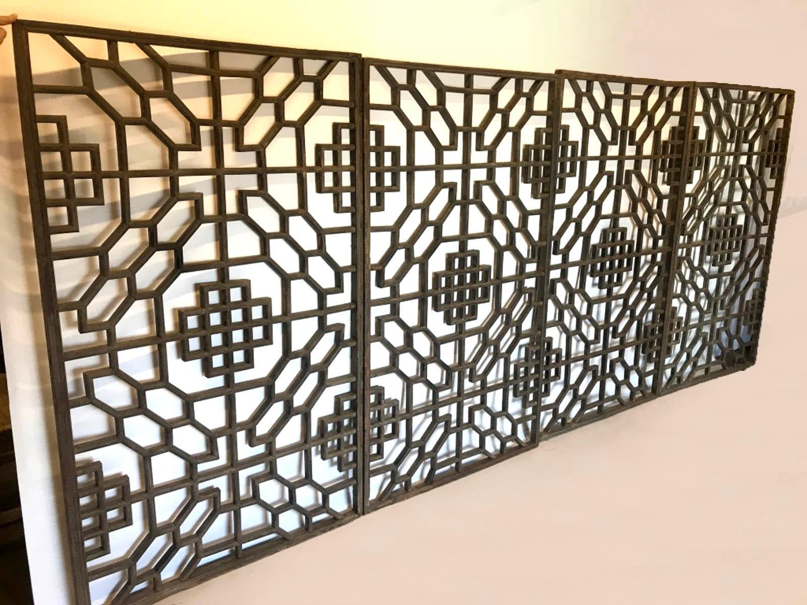 Set of four 19th century stunning, intricate lattice panels from Japan. Wood with naturally worn patina; traces of crackled finish. Each panel measures 35.5 inches wide and placed together they are 142 inches wide. The height is 60 inches, apart