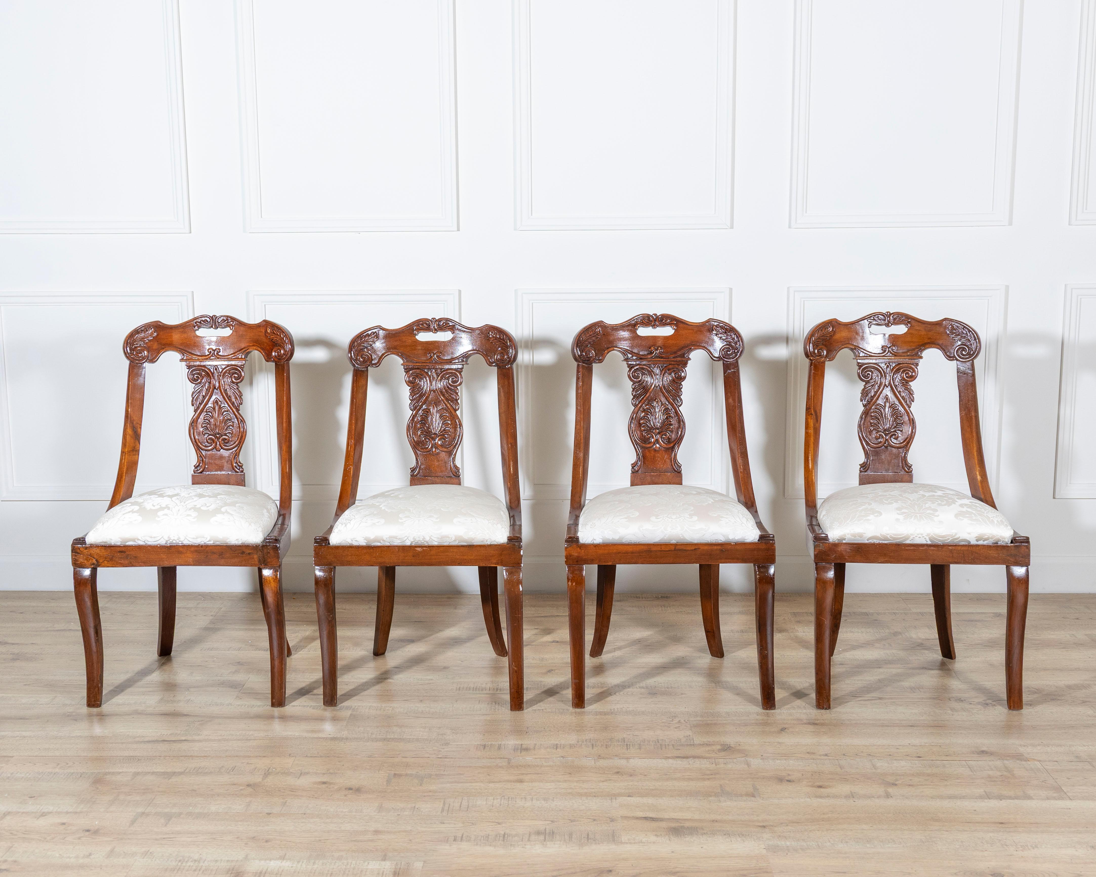 A graceful set of four Lombard gondola chairs from the first half of the 19th century, finely crafted in solid walnut. These elegant chairs exemplify the neoclassical Lombard tradition, with gently arched backrests and exquisitely carved central