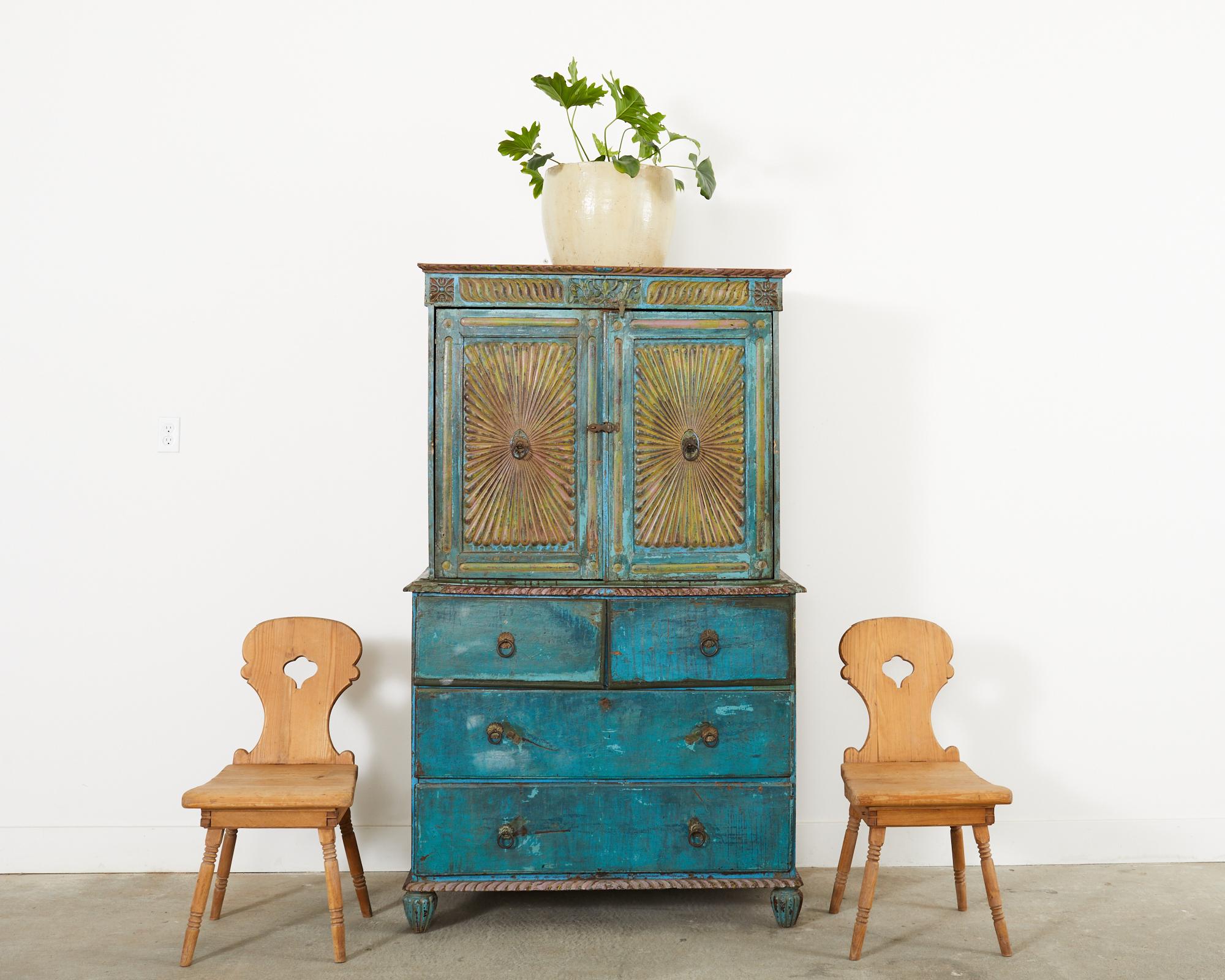 Rustic set of four 19th century primitive country Swedish hand-carved folk art farmhouse chairs crafted from pine. The set features a well-worn and weathered patina with a gracefully shaped back reminiscent of a Gustavian mora clock form. The thick,