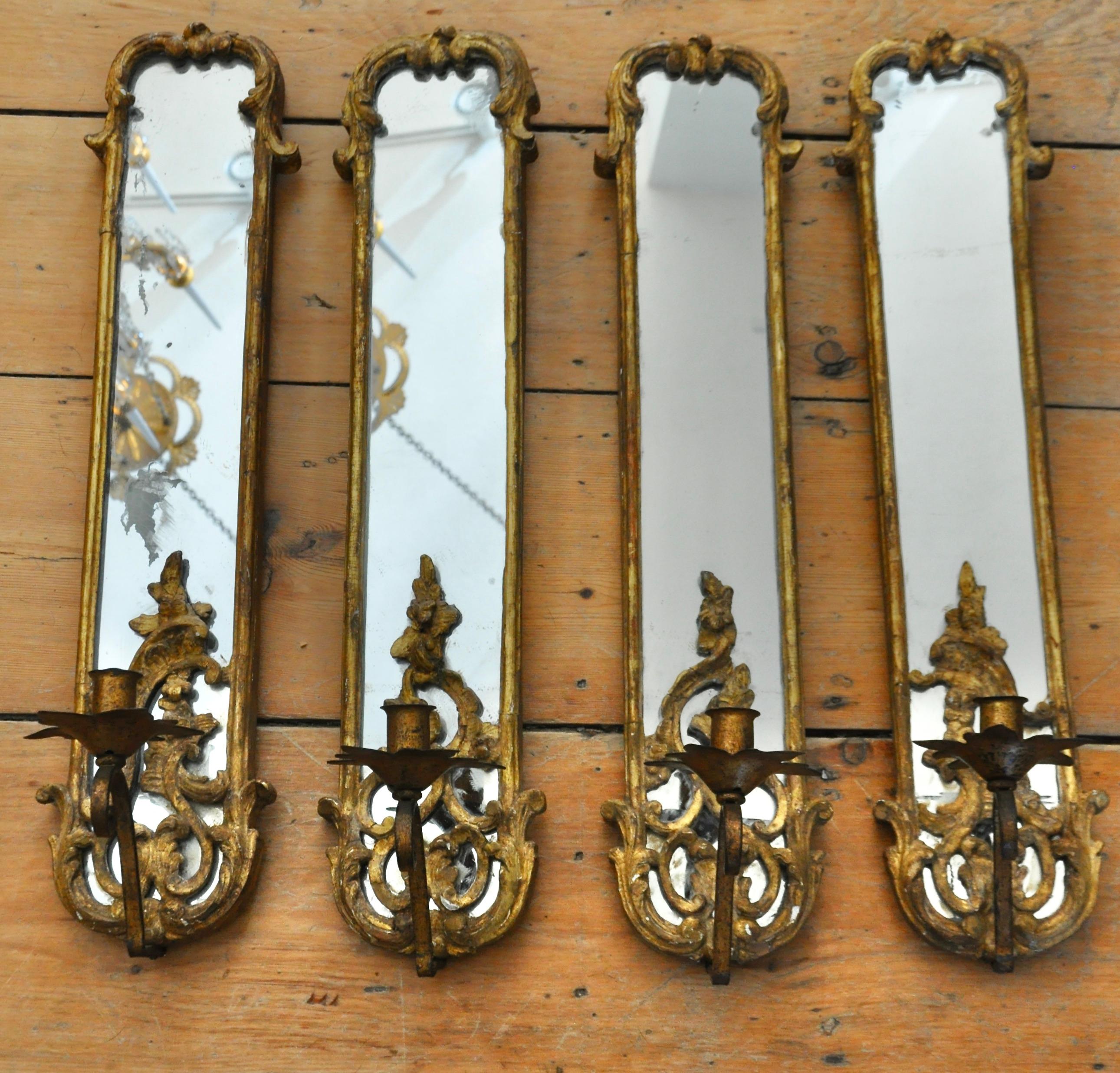 Set of 4 Rococo giltwood and iron mirror back sconces. Two matched pairs. Original gilding and mirror. Wrought iron candle holders.