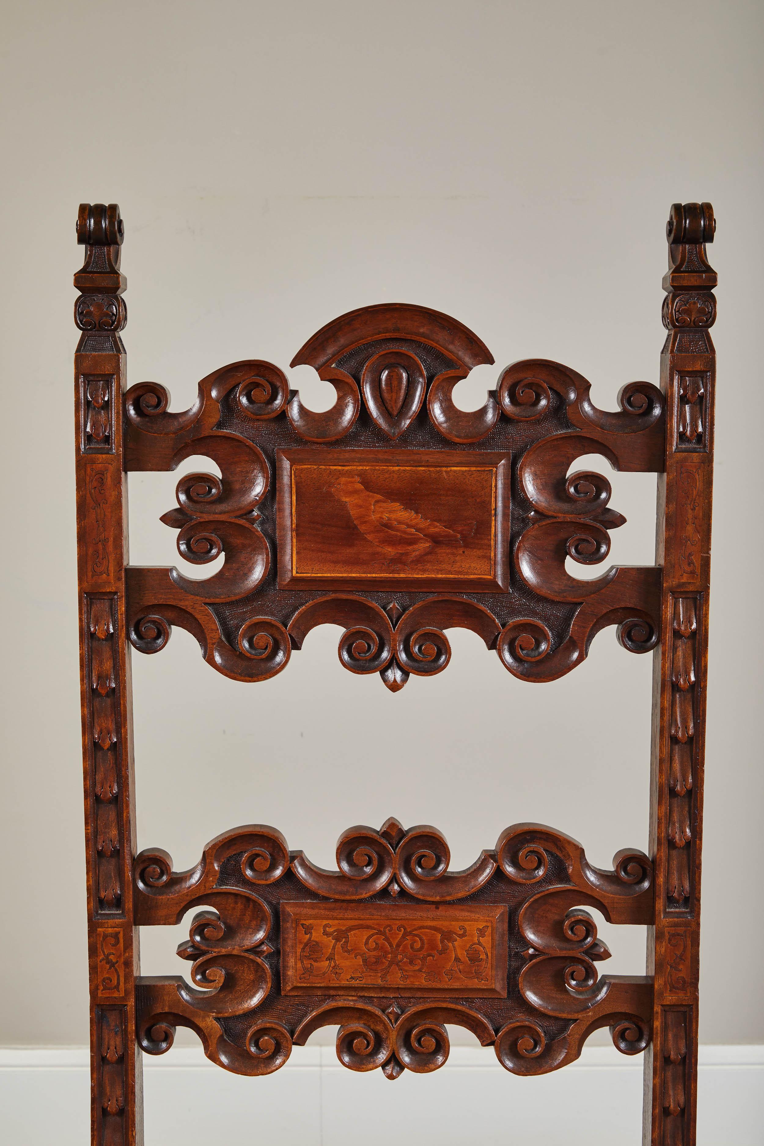 This is a set of four 19th century Spanish walnut renaissance Revival dining chairs. Recently reupholstered and refinished. Handsomely carved overall with fluid lines and graceful proportions. The carved open work back rests with two front panels.
