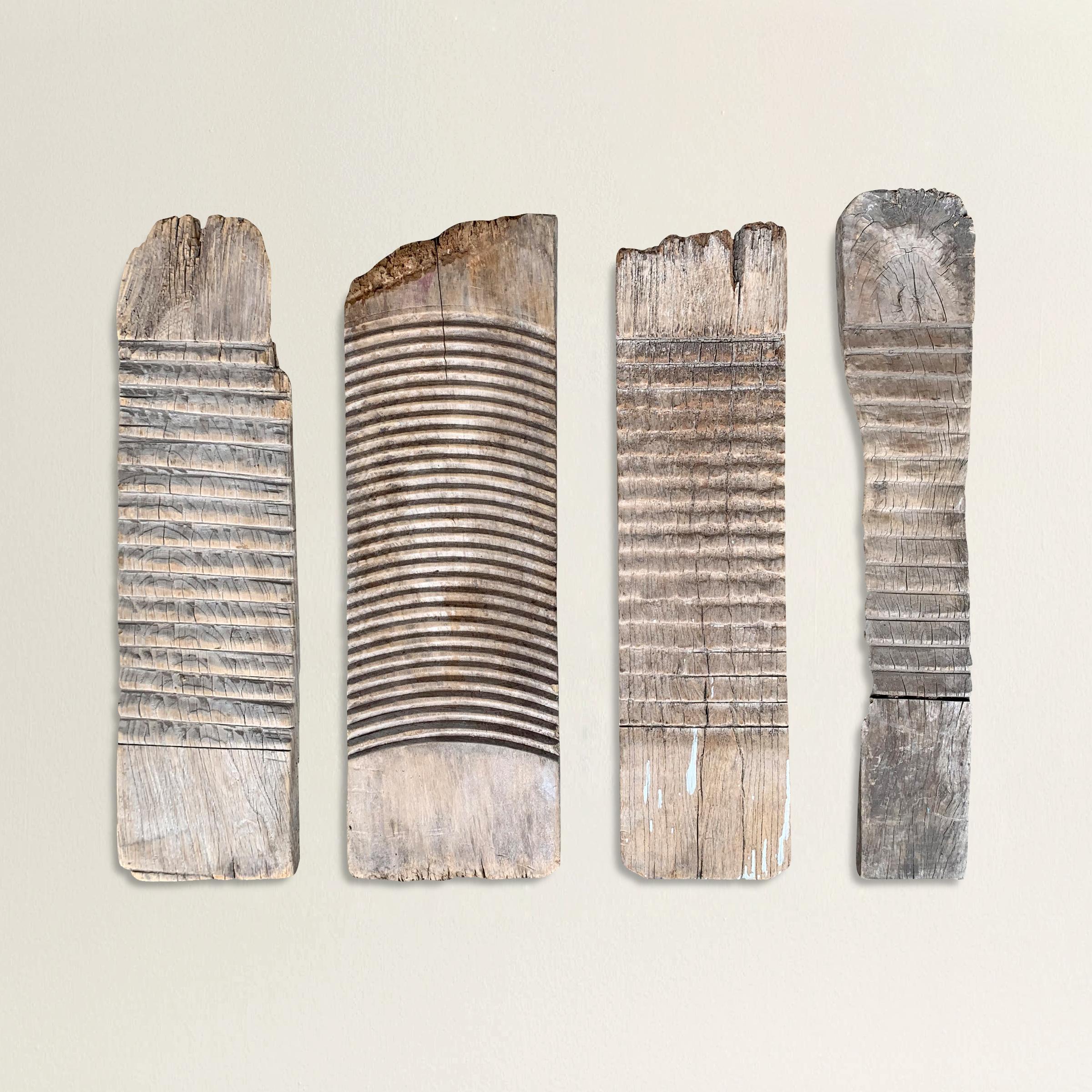 A remarkable set of four 19th century Eastern European carved wood washboards, all with well-worn and smooth driftwood finishes. Mounted on custom wall mounts.
