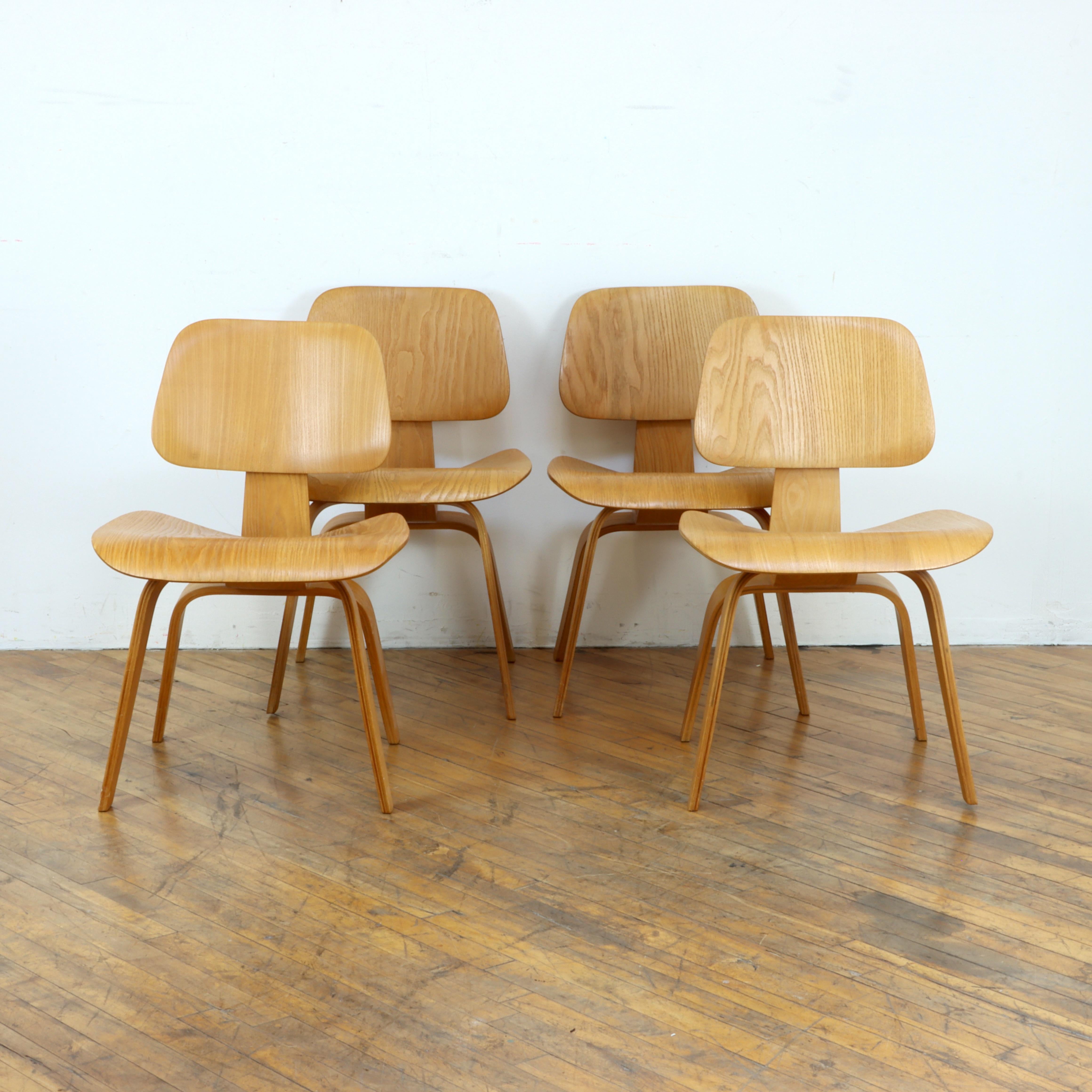 Besitzen Sie ein Stück Designgeschichte mit diesem seltenen Satz von Eames DCW-Stühlen der 1. Generation, die von Evans in Calico Ash hergestellt wurden. Bei einem Stuhl sind noch alle originalen Stoßdämpferhalterungen mit Unterlegscheiben