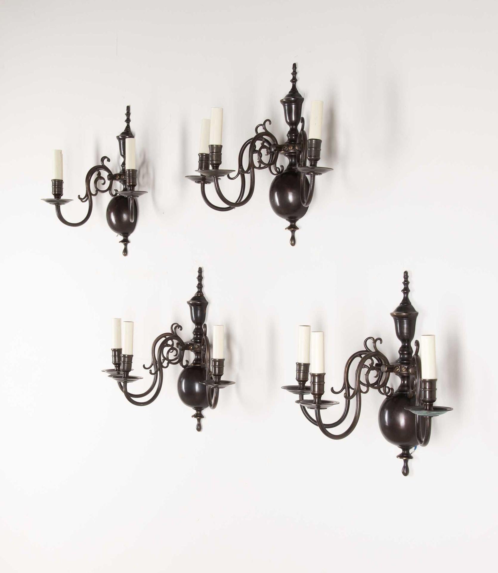 Juego a buena escala de cuatro apliques de pared de latón fundido y acabado en bronce de principios del siglo XX. En el clásico estilo holandés, pero de fabricación inglesa. En torno a 1920, totalmente recableada según las normas británicas. Incluye