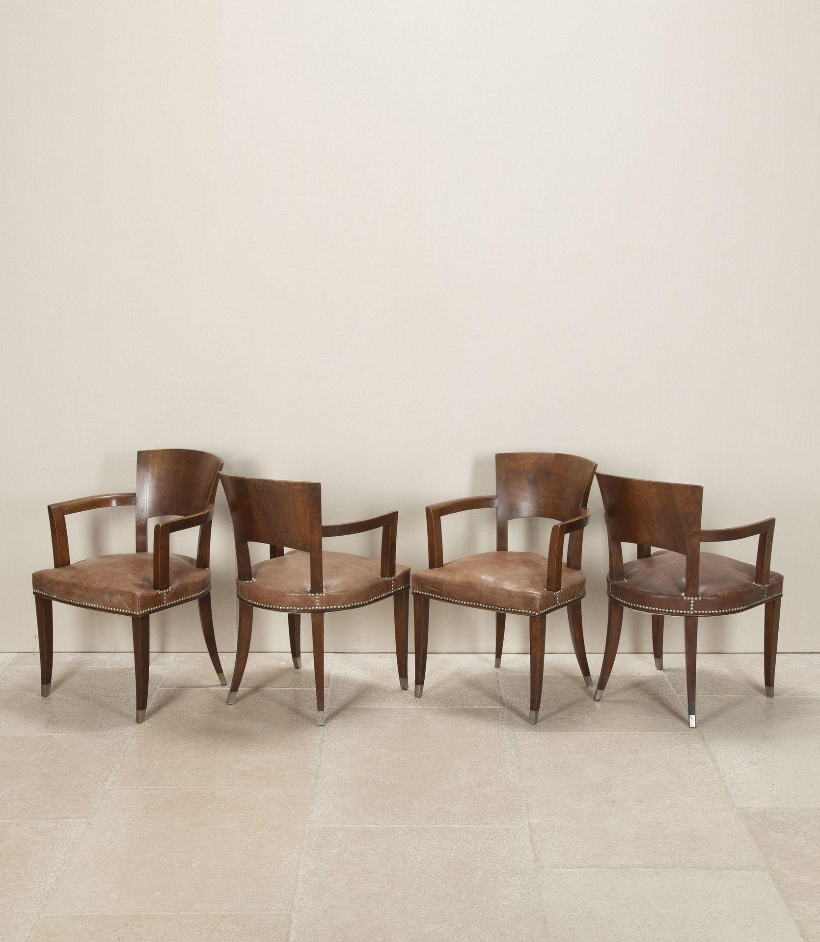Set of four 20th Century French Art Deco walnut bridge style armchairs in the manner of Ruhlmann. The tapered front and curved back legs terminate on metal sabots, typical of the Ruhlmann style. They are beautifully made and offer great comfort and