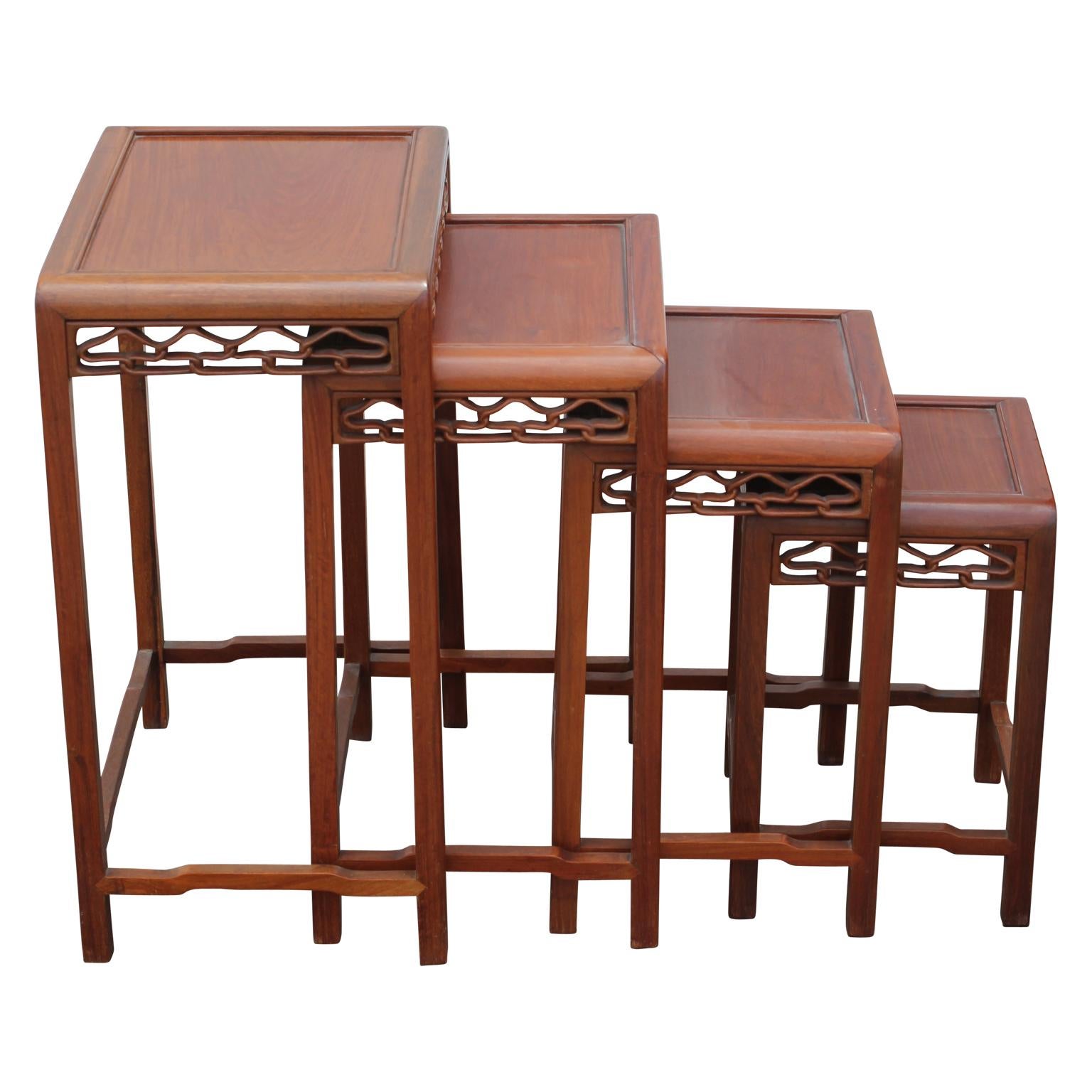 Beautiful 20th century carved nesting tables. They are Chinese in origin and are made from a stunning camphor wood. The tables feature carvings on the sides attached to the table tops. The tables can be placed separately or stacked