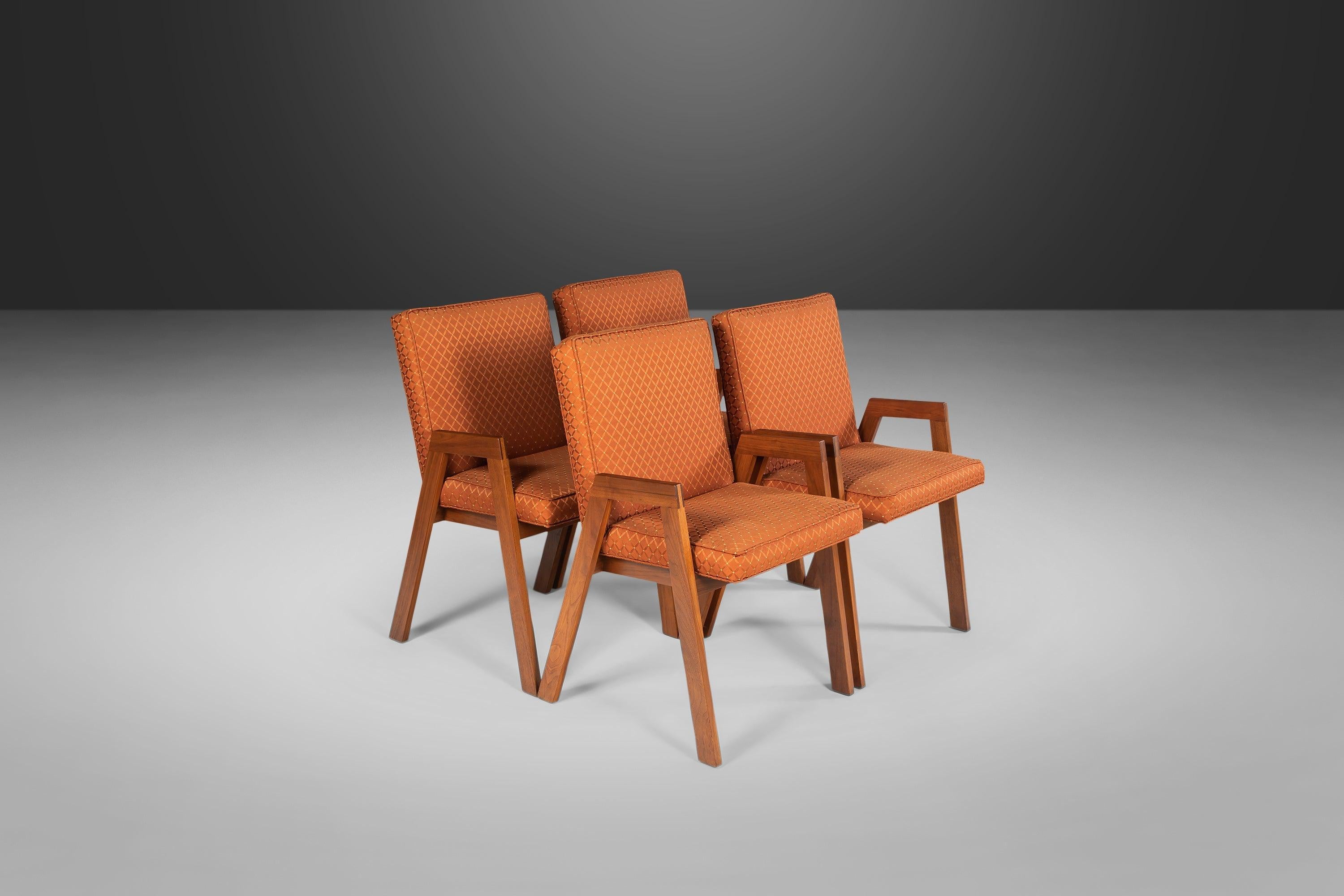 Minimal and angular. Constructed from walnut and found in a period orange upholstery. Circa 1960s.

---Dimensions---

Width: 21 in / 53.34 cm
Depth: 23 in / 58.42 cm
Height: 33.5 in / 85.09 cm
Seat Height: 19 in / 48.26 cm
Arm Height: 23.5 in /