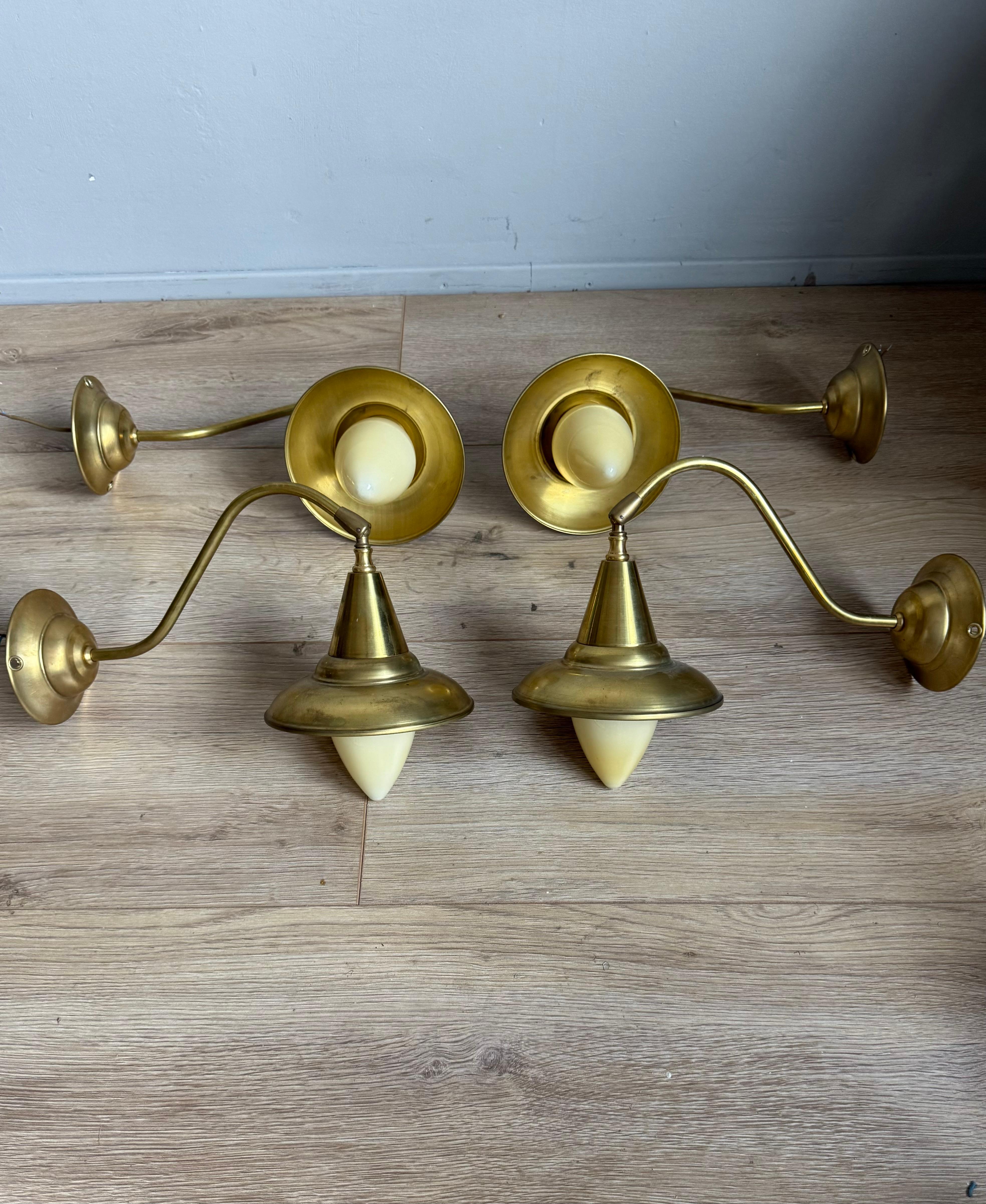 Des appliques murales au design intemporel et faciles à monter de l'époque du Midcentury.

Un ensemble saisissant de quatre appliques murales du milieu du siècle, fabriquées en laiton massif avec d'élégants diffuseurs en verre opalin. Chaque lampe
