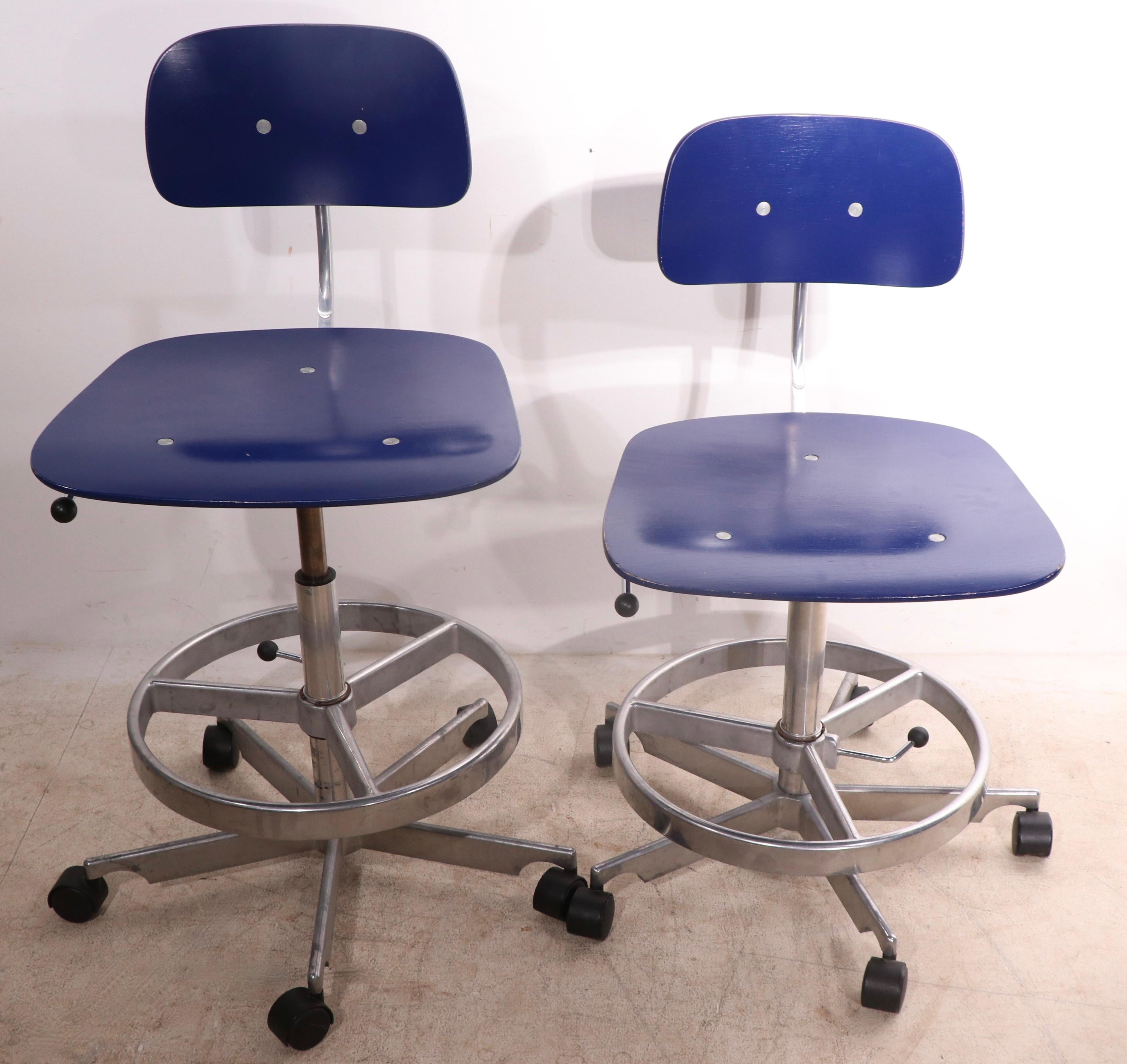 Sophisticated, architectural,  set of four adjustable swivel stools by Jorgen Rasmussen for Fritz Hansen.  Constructed of blue finish  bent plywood, on chrome and aluminum bases, with black plastic wheel coaster feet. In addition to the swivel