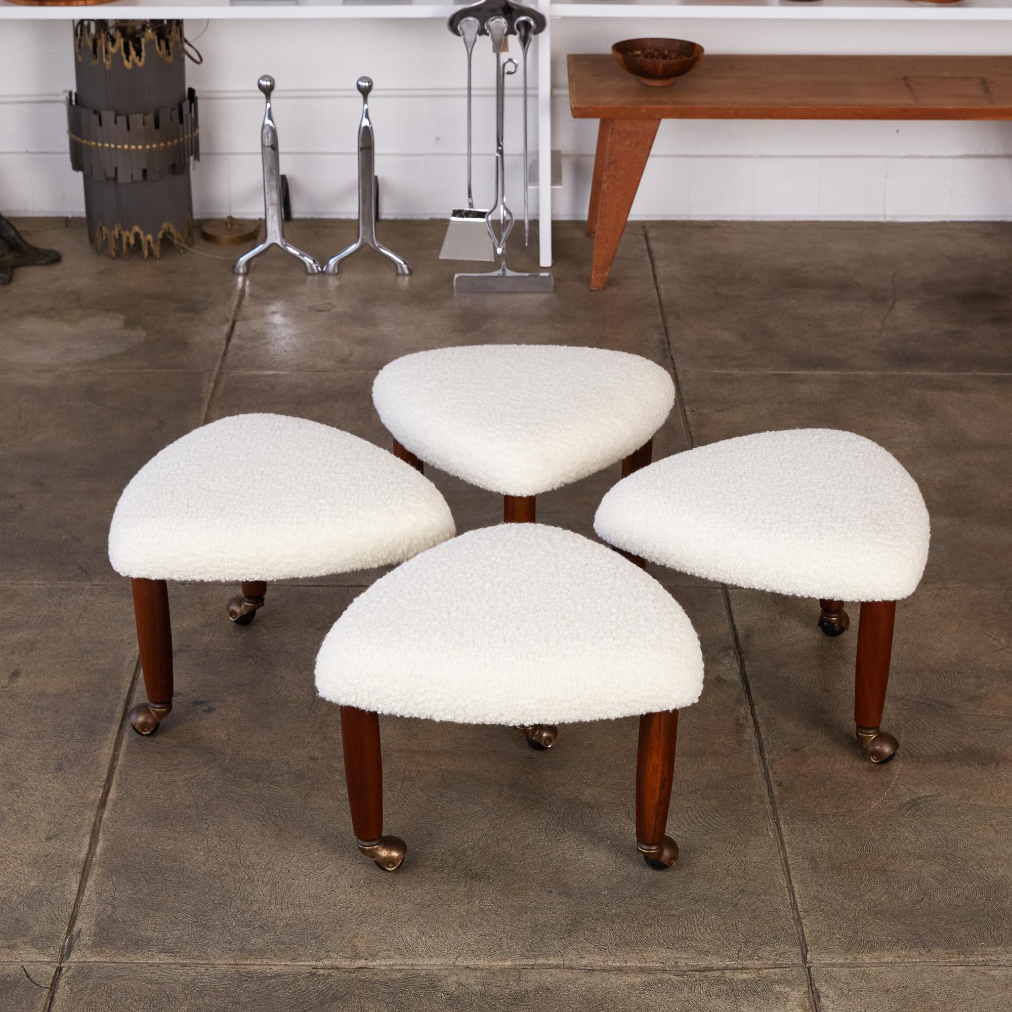 Adrian Pearsall for Craft Associates guitar pick stools. This set of four stools feature new white bouclé upholstery on their triangle shaped seats which sit upon three turned slightly tapered legs with round brass casters at their feet. These were