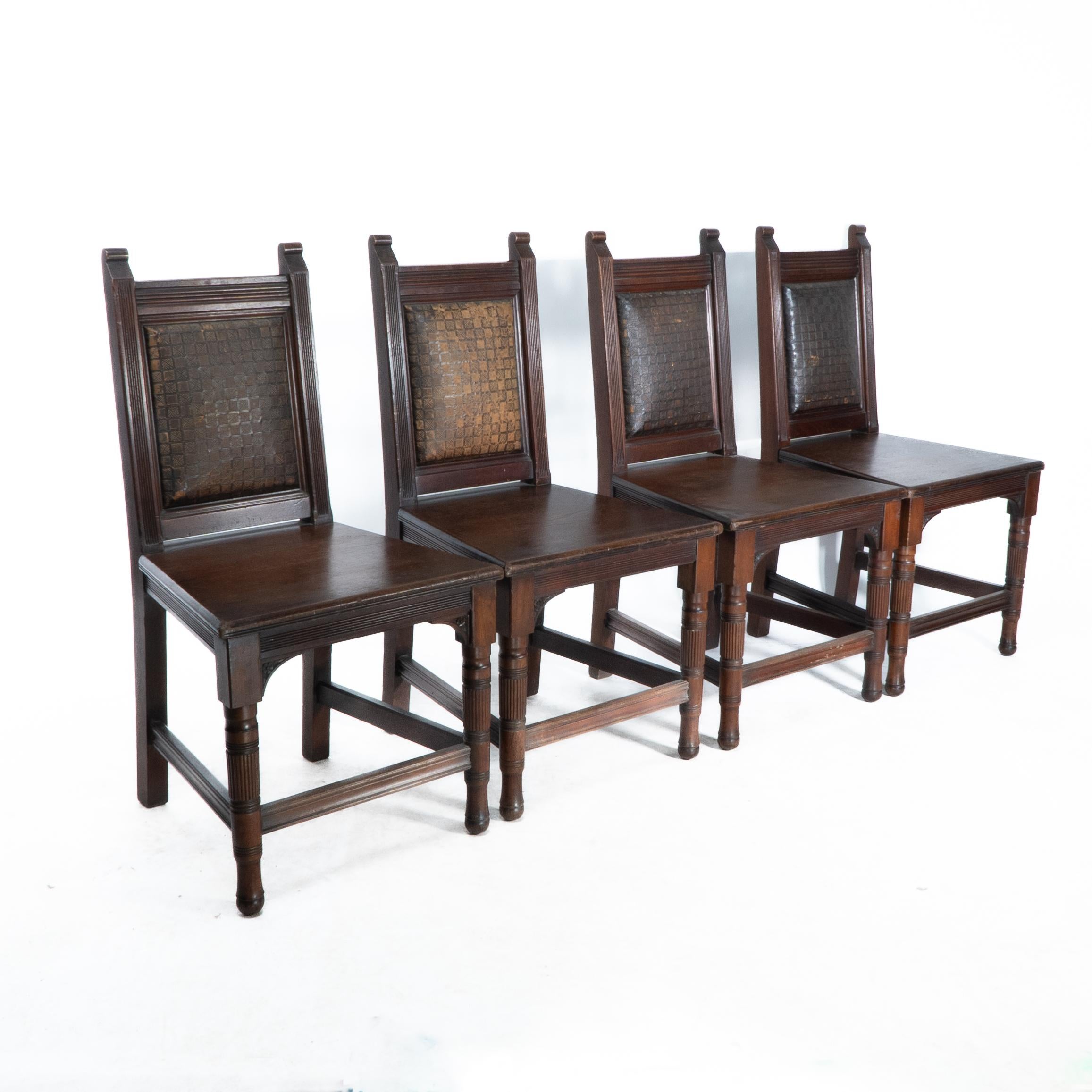 An Aesthetic Movement set of four walnut and chequer tooled leather hall chairs.
In the manner of Edward William Godwin. 
The embossed leather represents Japanese style basket weave a motif used by Godwin a number of times.
Price for the set