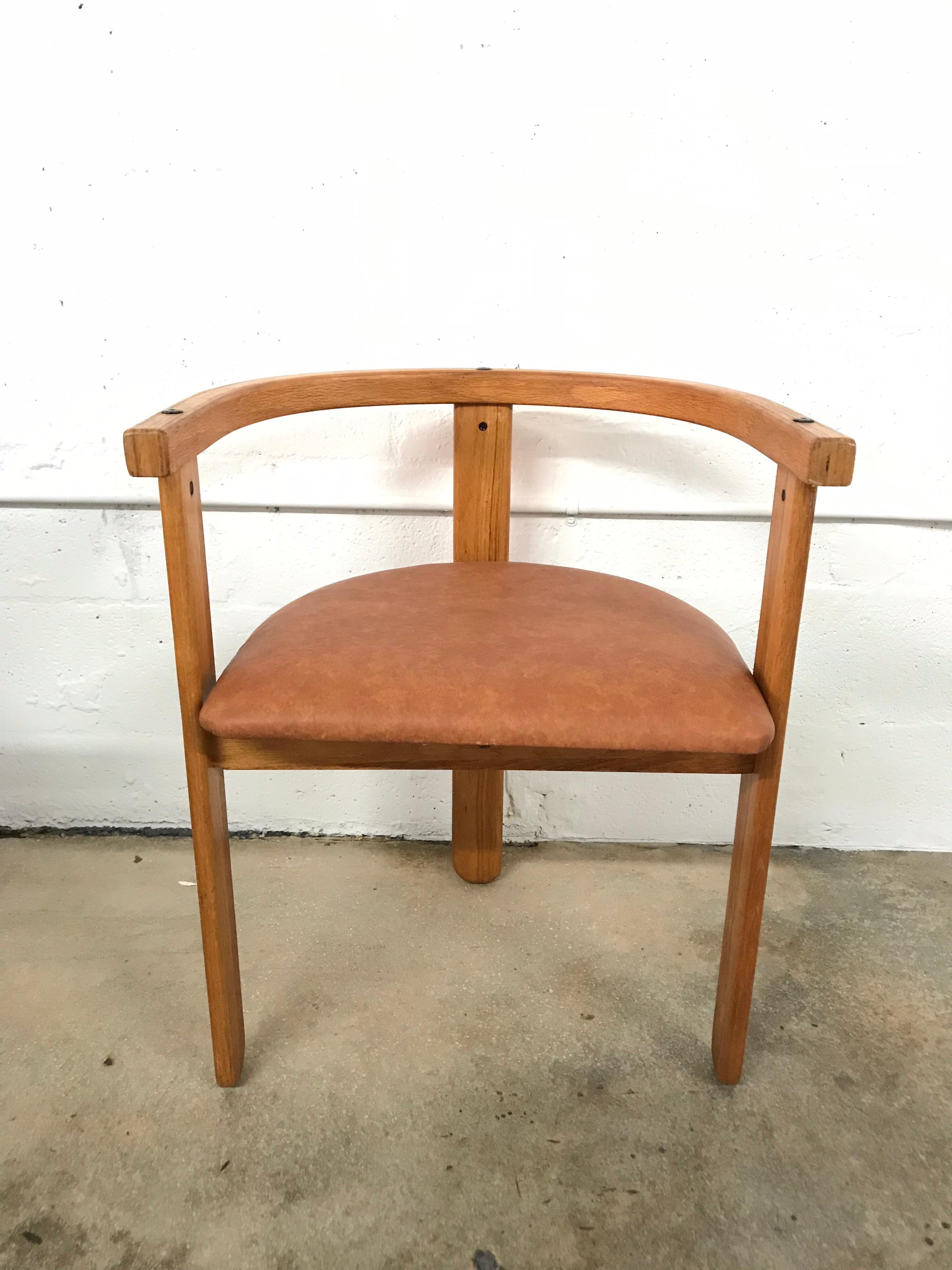 Set of four, three legged dining chairs rendered in oak with brown vinyl upholstery, style of Carlo Scarpa, circa 1968.