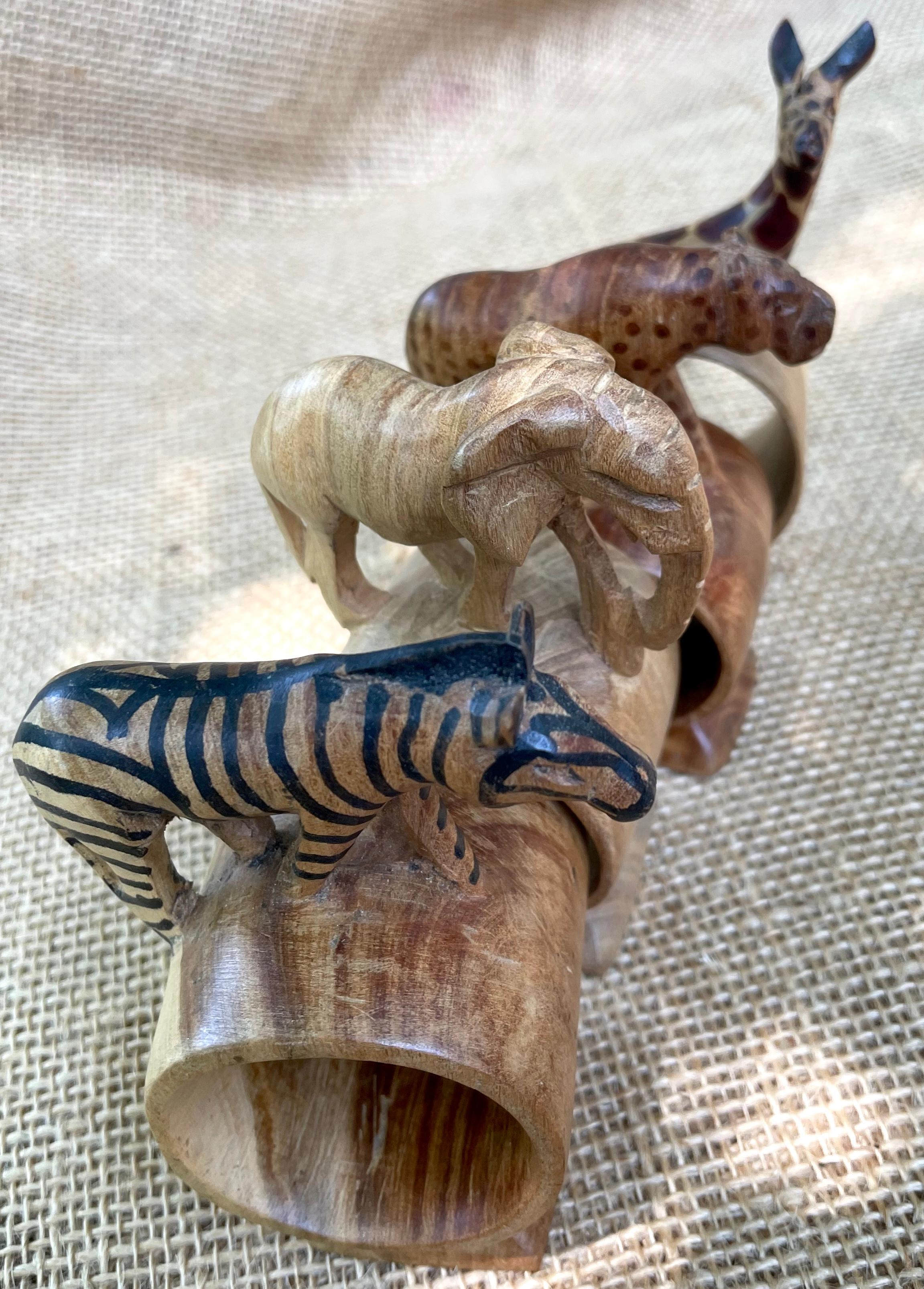Lot de quatre ronds de serviette African Safari. Figurines en bois d'olivier sculptées et teintées à la main, avec ronds de serviette intégrés, en provenance du Kenya. Éléphant, zèbre, léopard et girafe. Afrique, Milieu du siècle
Dimensions : 4