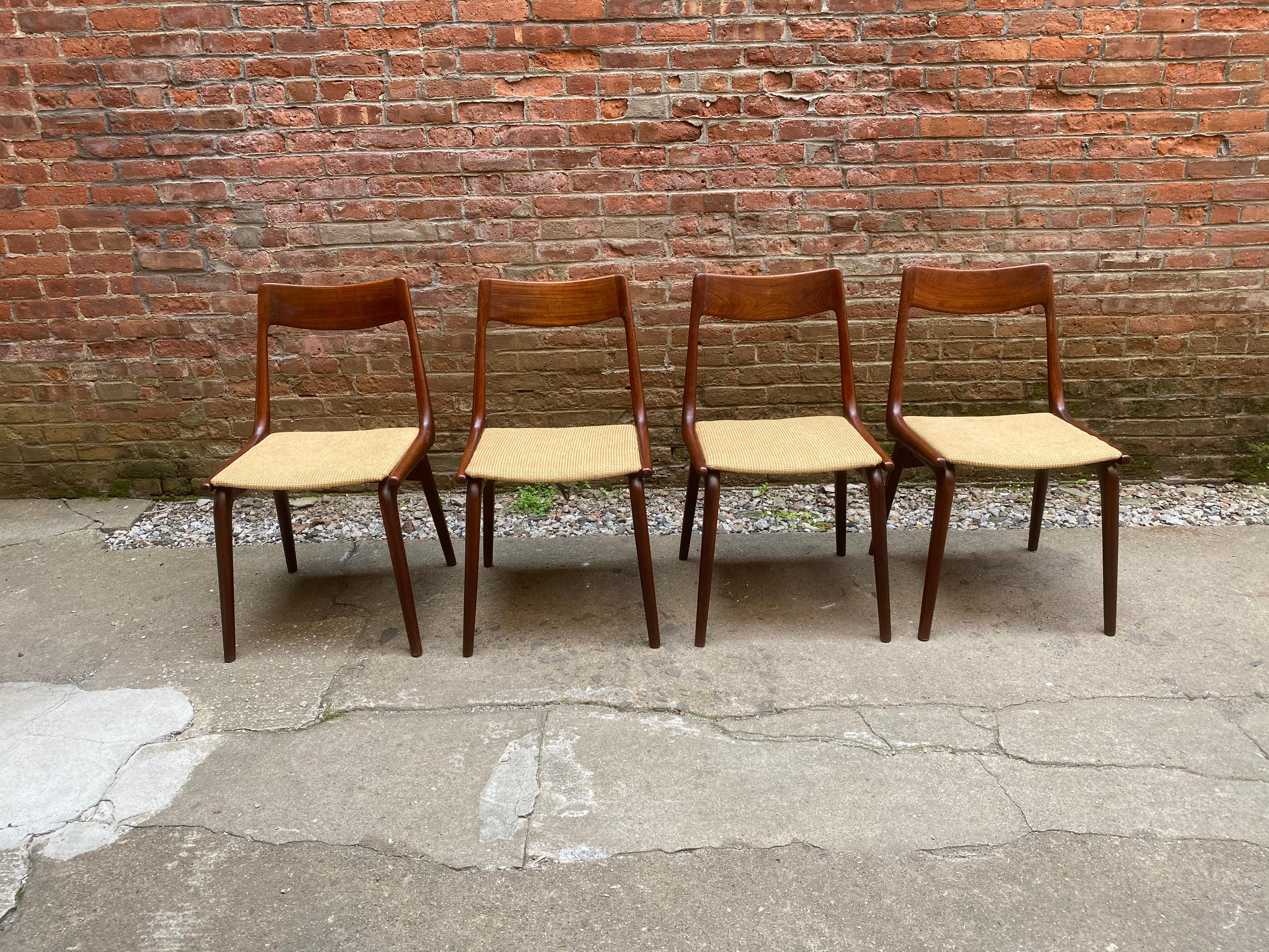 Set of four solid teak Danish modern Boomerang chairs designed by Alfred Christensen. Sculptural and ergonomically built for maximum comfort. A great chair with great lines and subtle details; box joint dovetailing, tapered legs and stretchers and