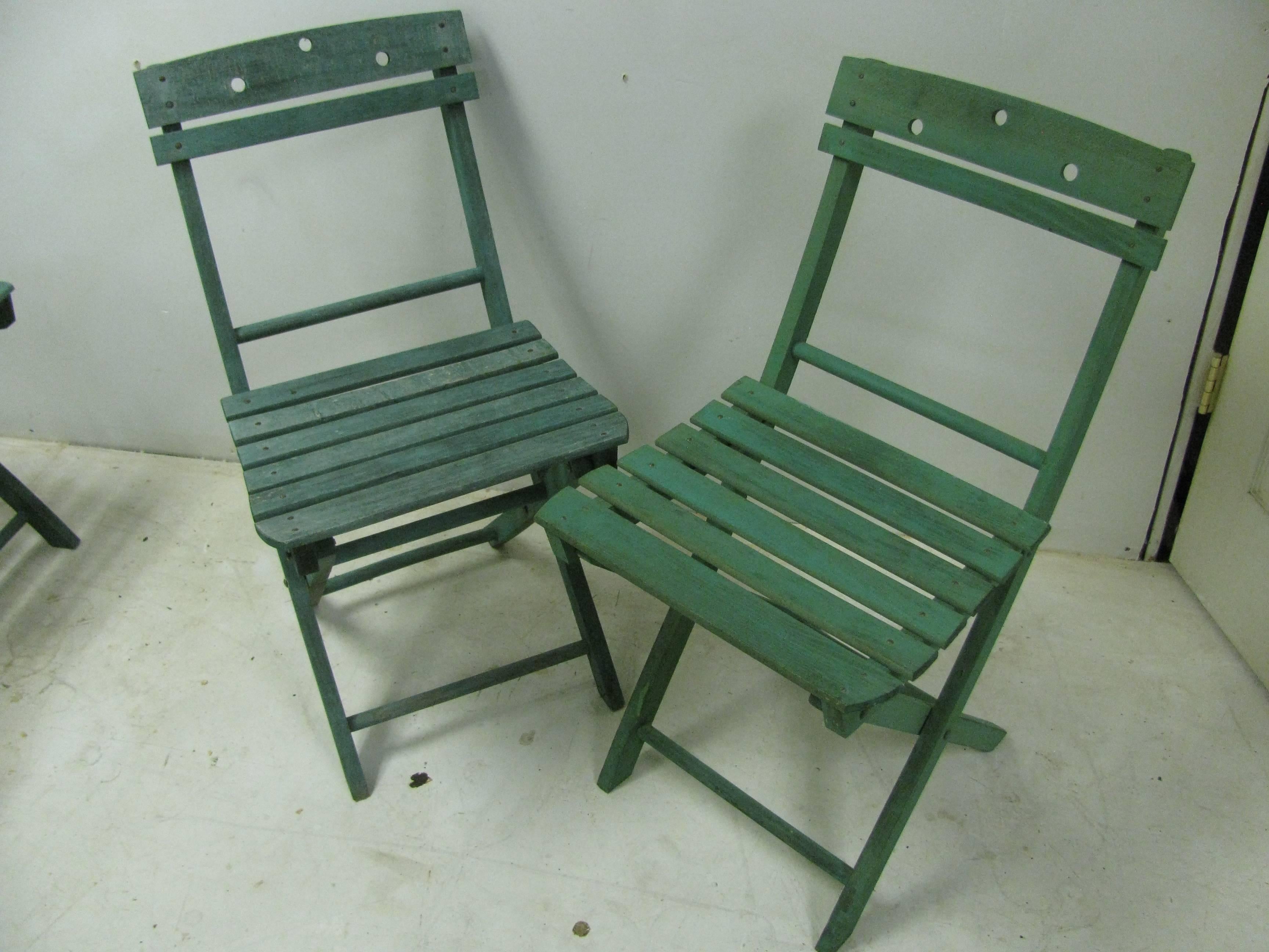 All original set of four all wood foldup cafe chairs, circa 1960. Original green paint, and sturdy in excellent condition, folds easily for storing. Two had sat outside in the sun and weather while two were inside most of their lives.