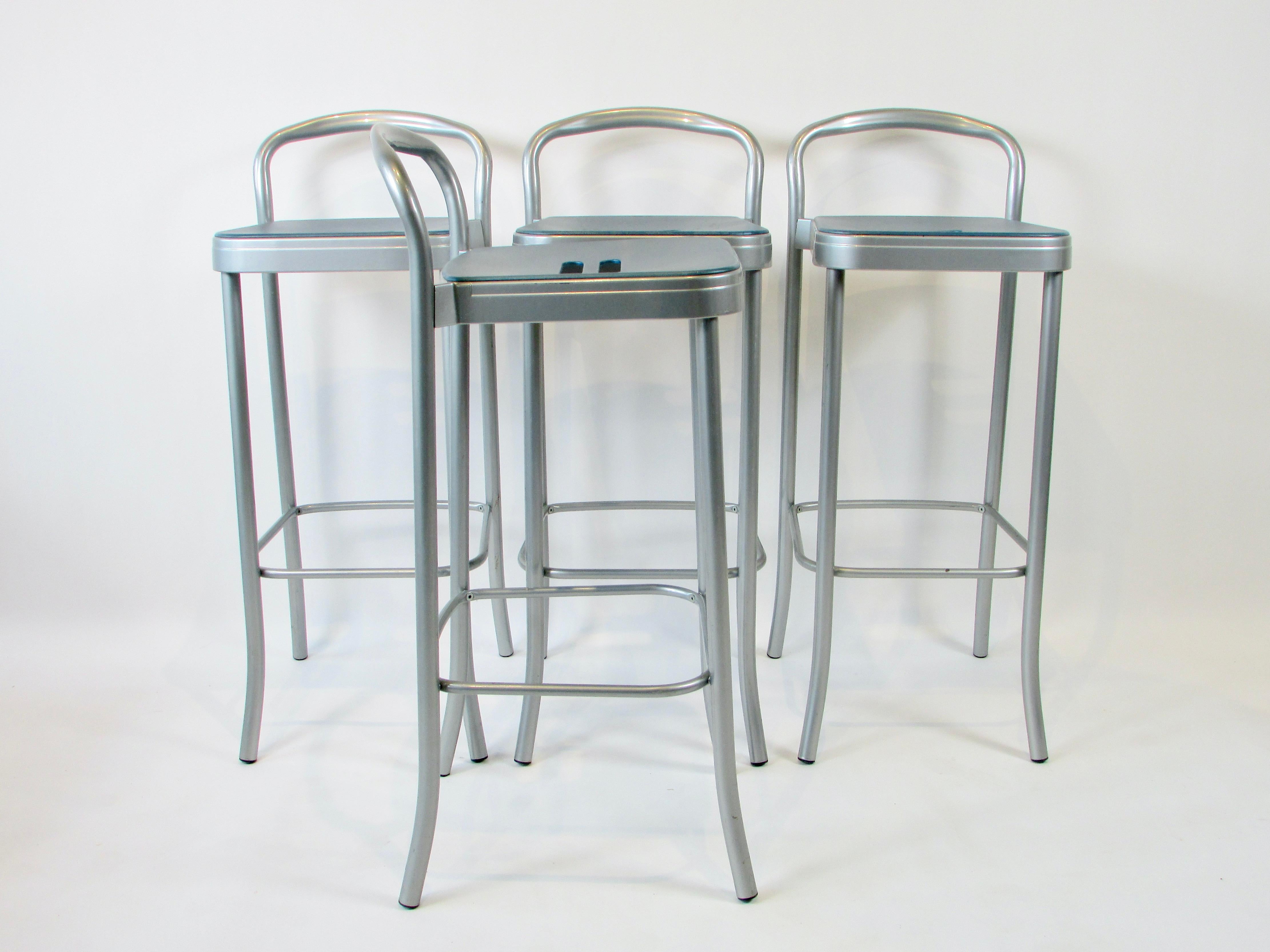 Four bar stools designed by Italian master Vico Magistretti for Kartell. Lightweight aluminum frames are powder coated supporting plastic seats with grab hole centers.