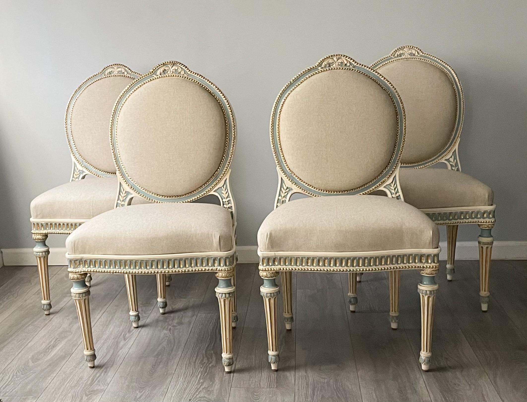 Gorgeous, French 19th C, set of 4 painted and parcel-gilt dining/side chairs chairs in the Louis XVI style.

The chairs feature detailed carved and painted decorations throughout with new cotton linen upholstery. 

Condition: Minor paint loss and