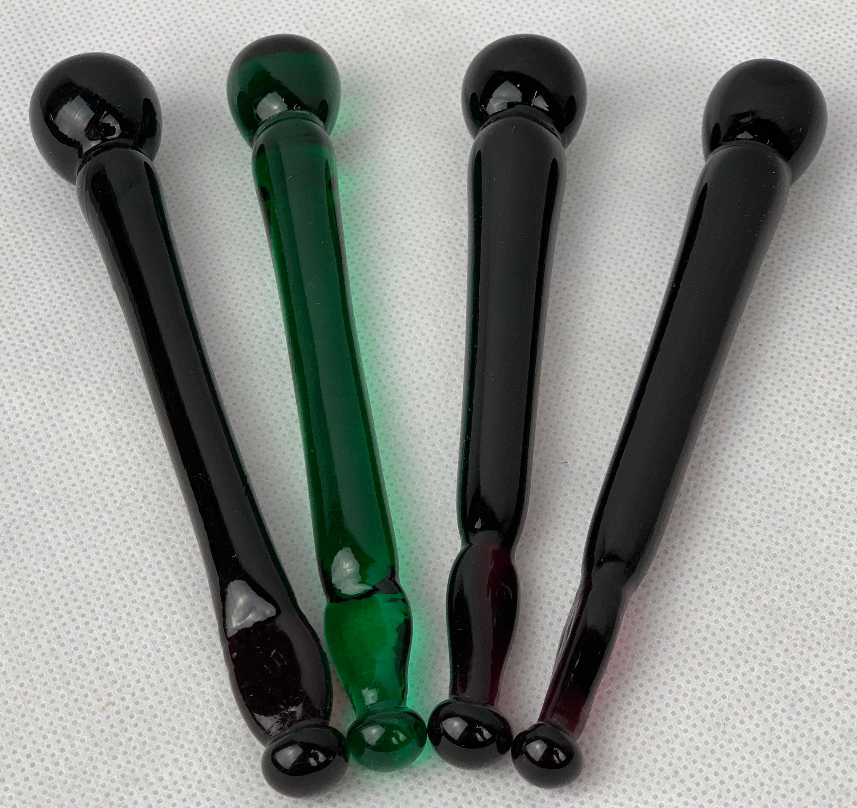 Set of four antique glass cocktail muddlers in dark purple and emerald green. They are a great bartender’s tool and sometimes called a swizzle stick. They usually have an enlarged tip useful for stirring drinks, crushing fruit, herbs and spices all