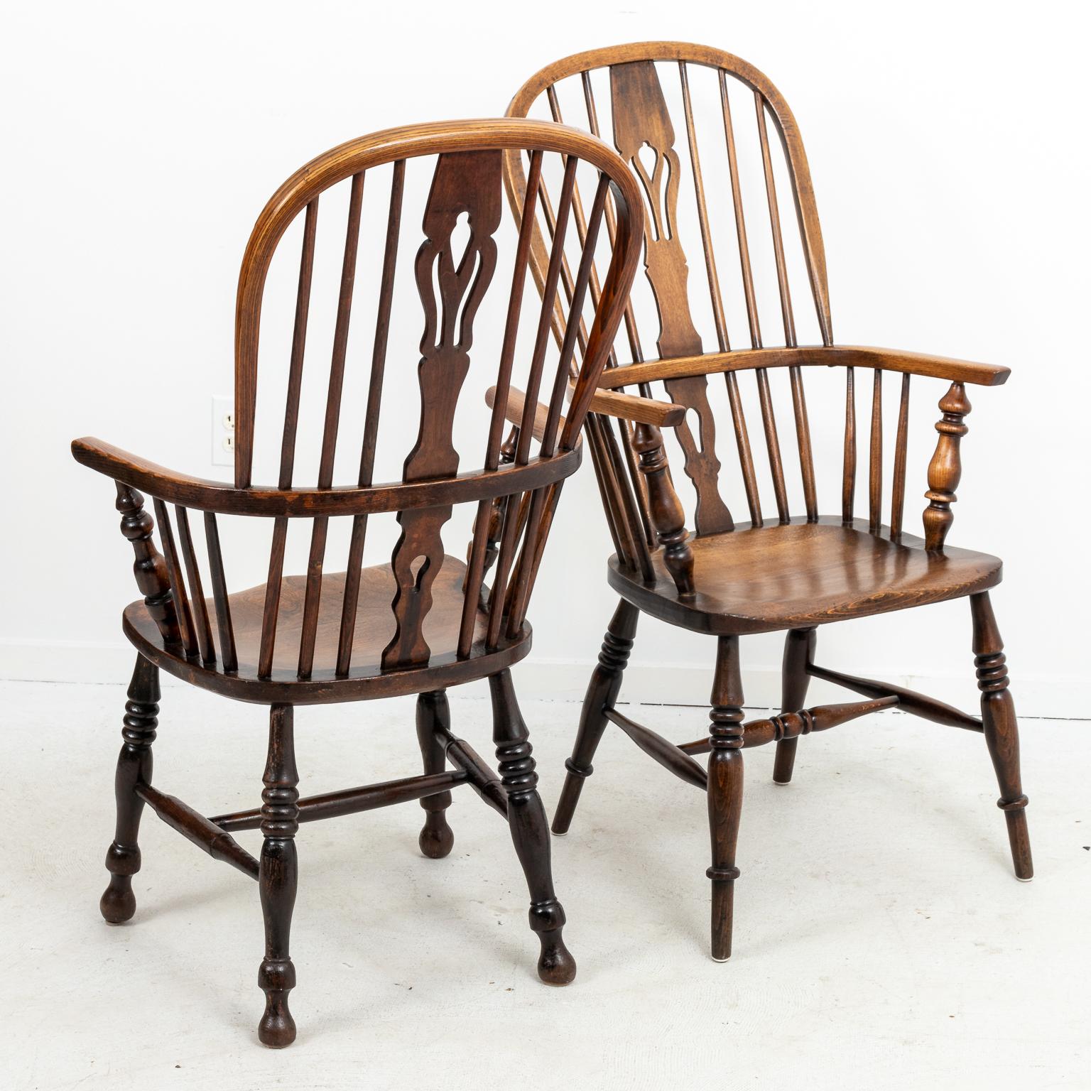 Set of four antique oakwood Windsor style armchairs with comb backs. Please note of wear consistent with age including finish loss.