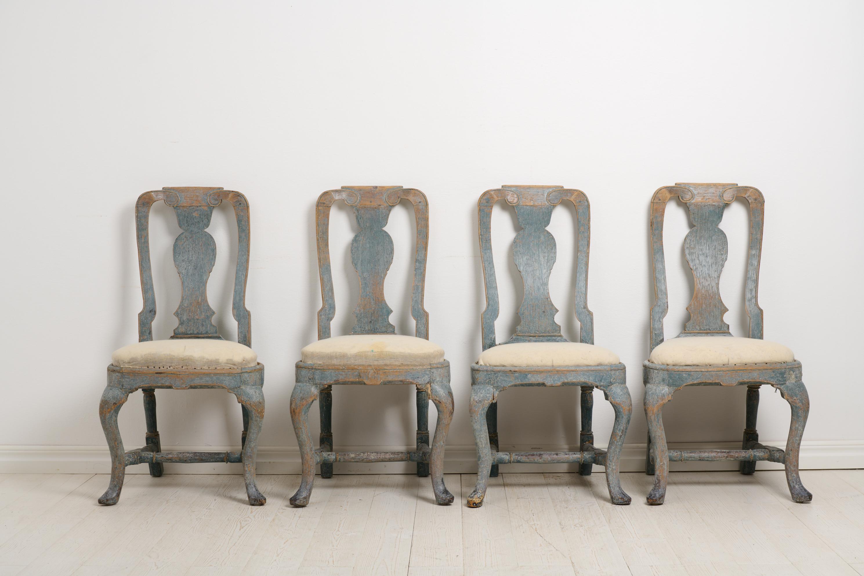 Antique Swedish chairs from the late Baroque period, around 1770. This is a set of four chairs which are an original set and have been together since the making. Scraped to the original blue paint from the late 1700s. The paint has some distress and