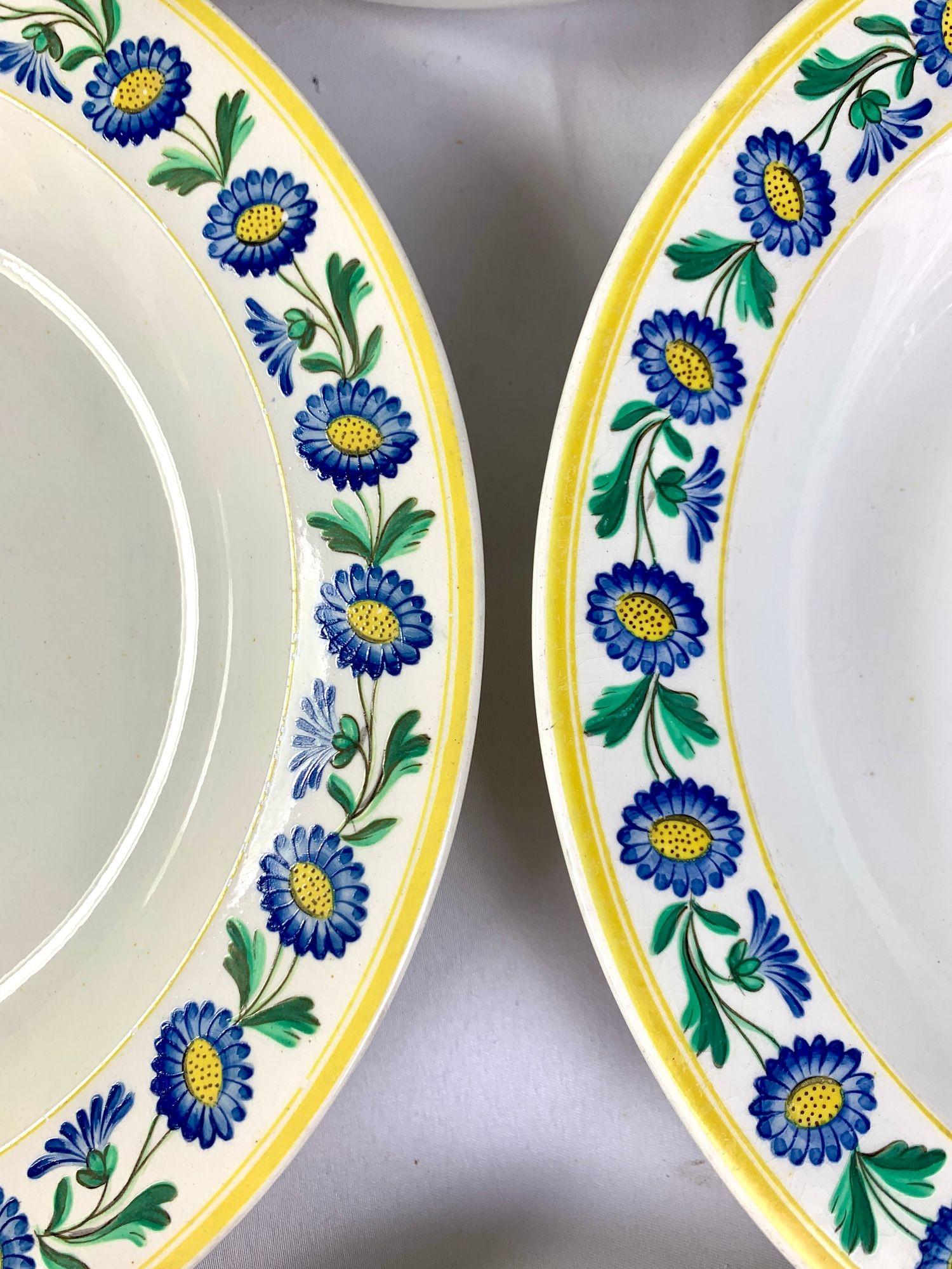 Dieses Set aus vier antiken Wedgwood-Perlengeschirren mit handgemalten Emaillen ist mit dem charmanten Muster Nr. 967 verziert. Das Design zeigt eine lebendige Bordüre aus handgemalten blauen und gelben Gänseblümchen mit grünem Laub, eingerahmt von