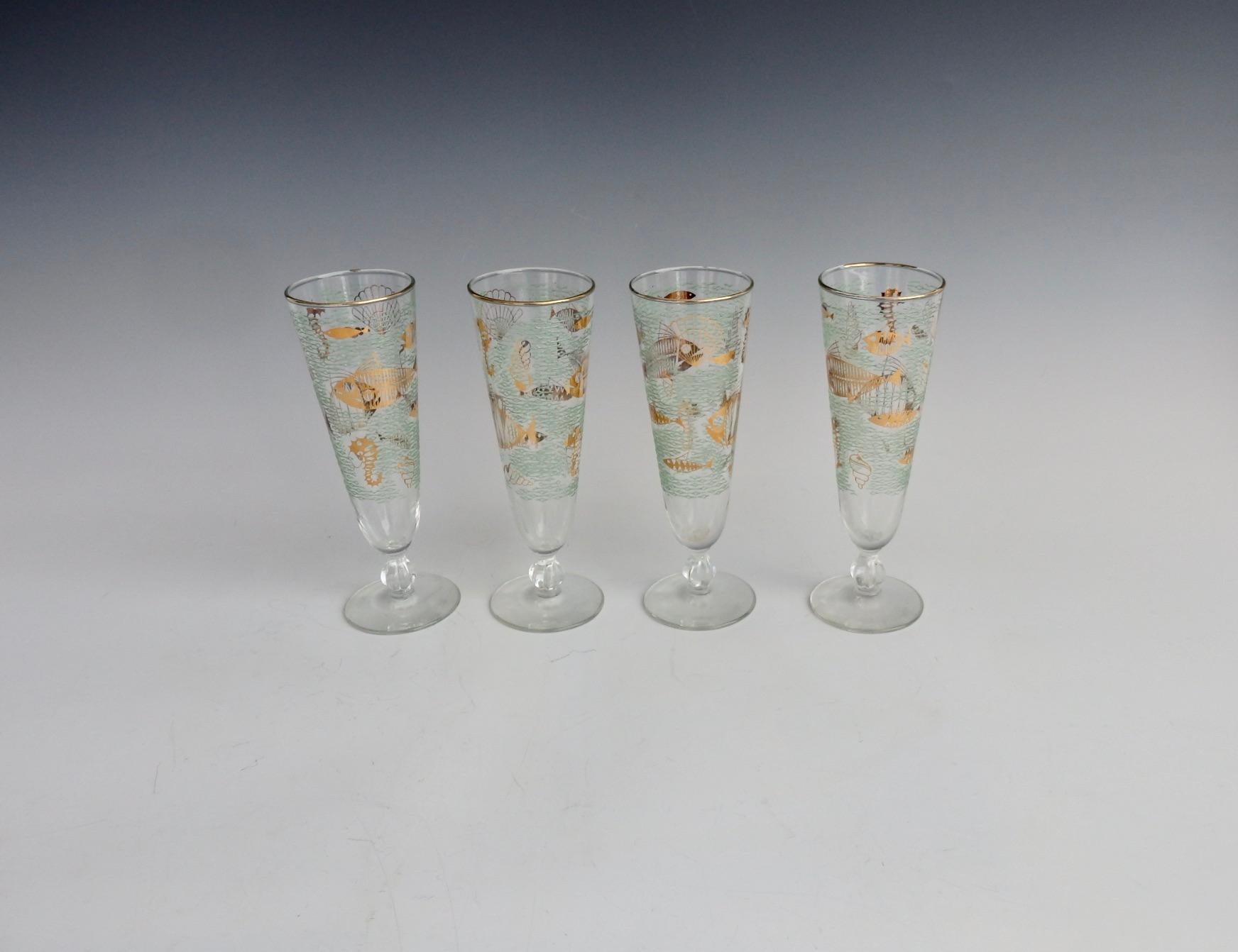 Four pilsner glasses. Nicely decorated with ocean like rippled aqua lines in textured finish accenting and stylized sea life.