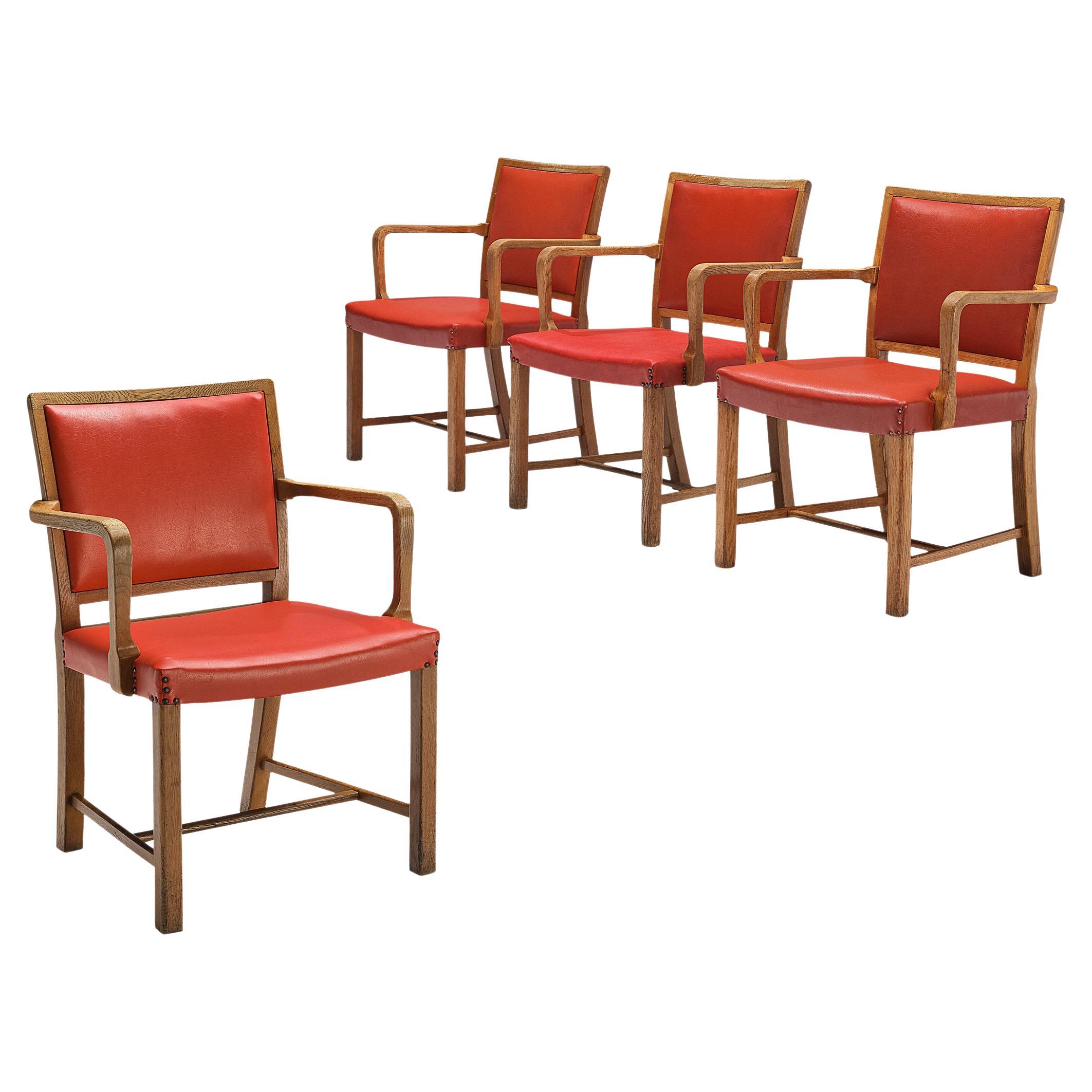 Ensemble de quatre fauteuils en chêne et similicuir rouge