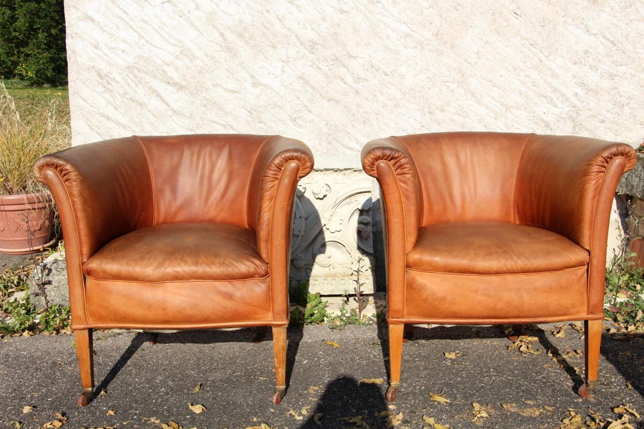 Raro set di quattro poltrone club a botte di epoca Art Déco in pelle color avana. Sono in condizioni di usato, con un'usura minima. Una molla sul sedile di una delle poltrone si è allentata (deve essere ritensionata). Le pelli sono generalmente in