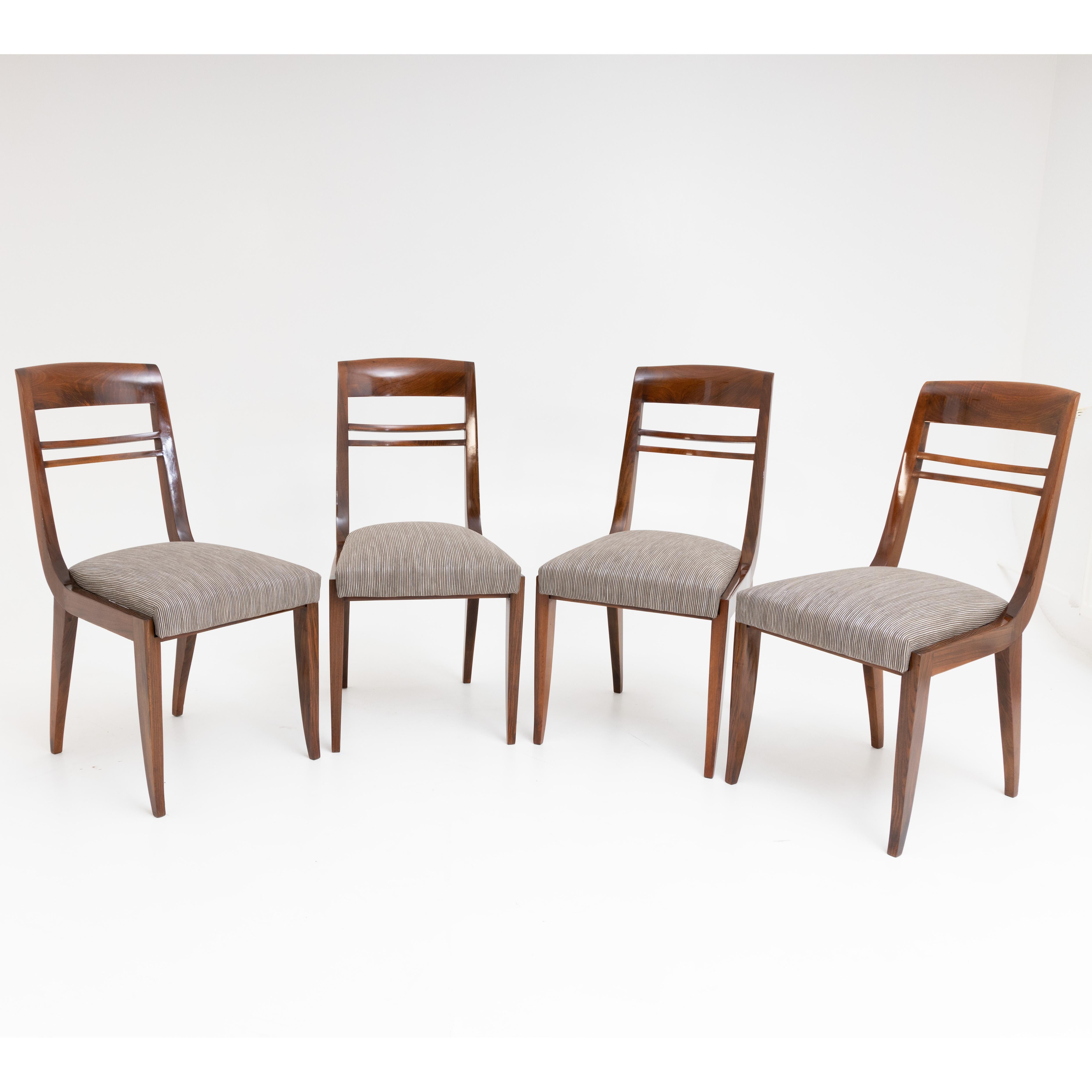 Ensemble de quatre chaises Art Déco à assise et dossier rembourrés avec double entretoise centrale. Les chaises ont été récemment recouvertes d'un tissu rayé argent et noir.