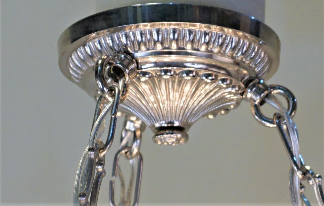Satz von vier eleganten französischen Art-Déco-Kronleuchtern mit sechs Lichtern. Diese Gläser aus den 1930er Jahren sind mit einem stilisierten geometrischen Schliff verziert und haben Beschläge aus Nickelbronze.