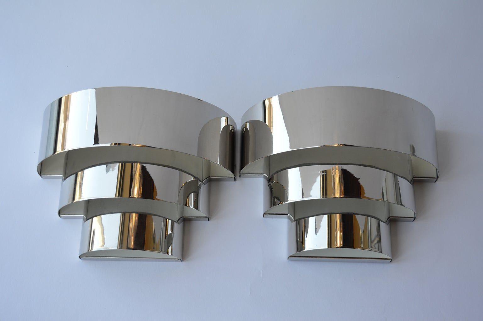 Set of four Art Deco chrome sconces.
Two candelabra light bulbs per sconce.