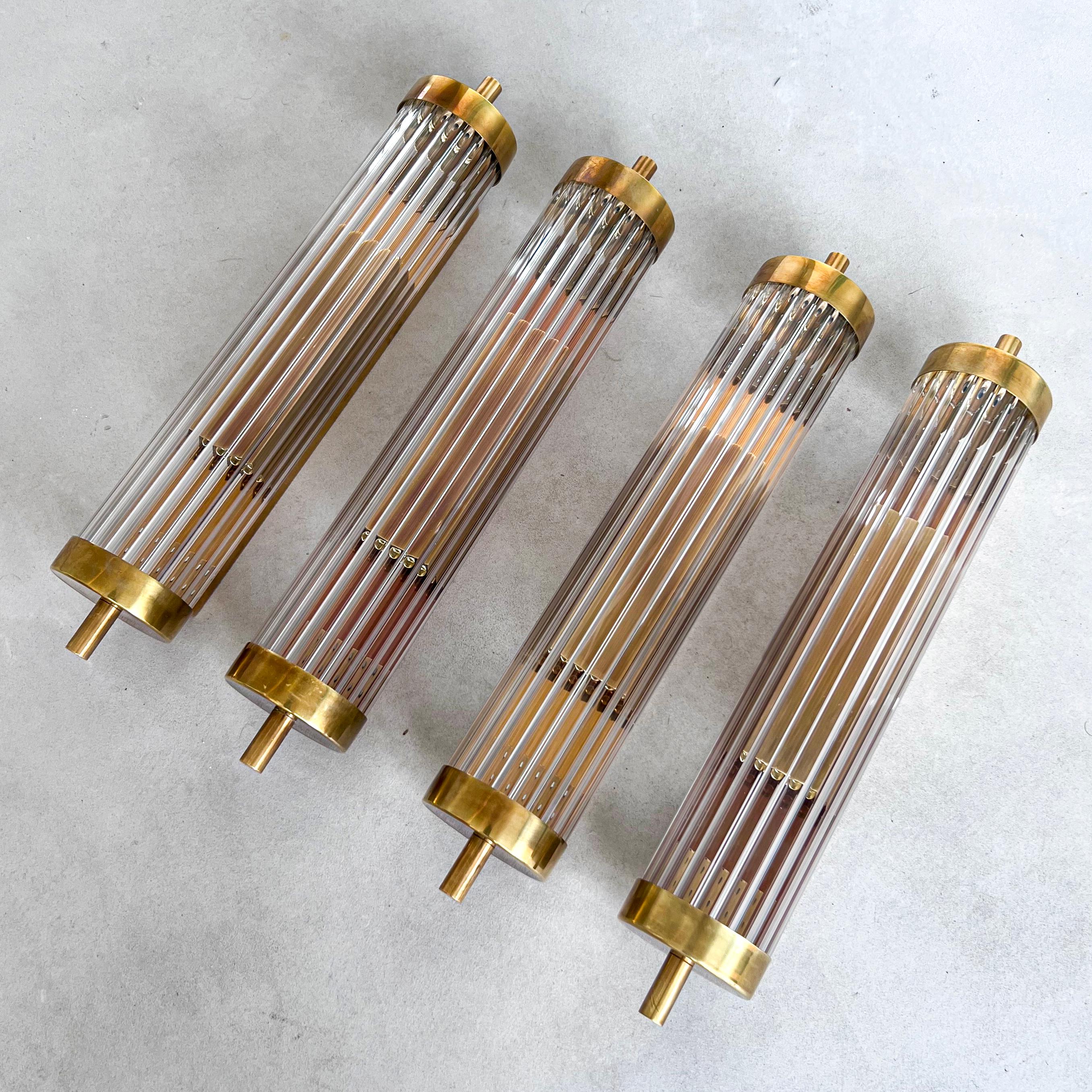 Wall lamps Applique for Vanity or Wall Sconces - Modern Mid Century Italian Lighting 

Offered for sale is a set of four stunning contemporary wall lights, designed and hand crafted in Milano, Italy by expert artisans using brass and fluted glass.