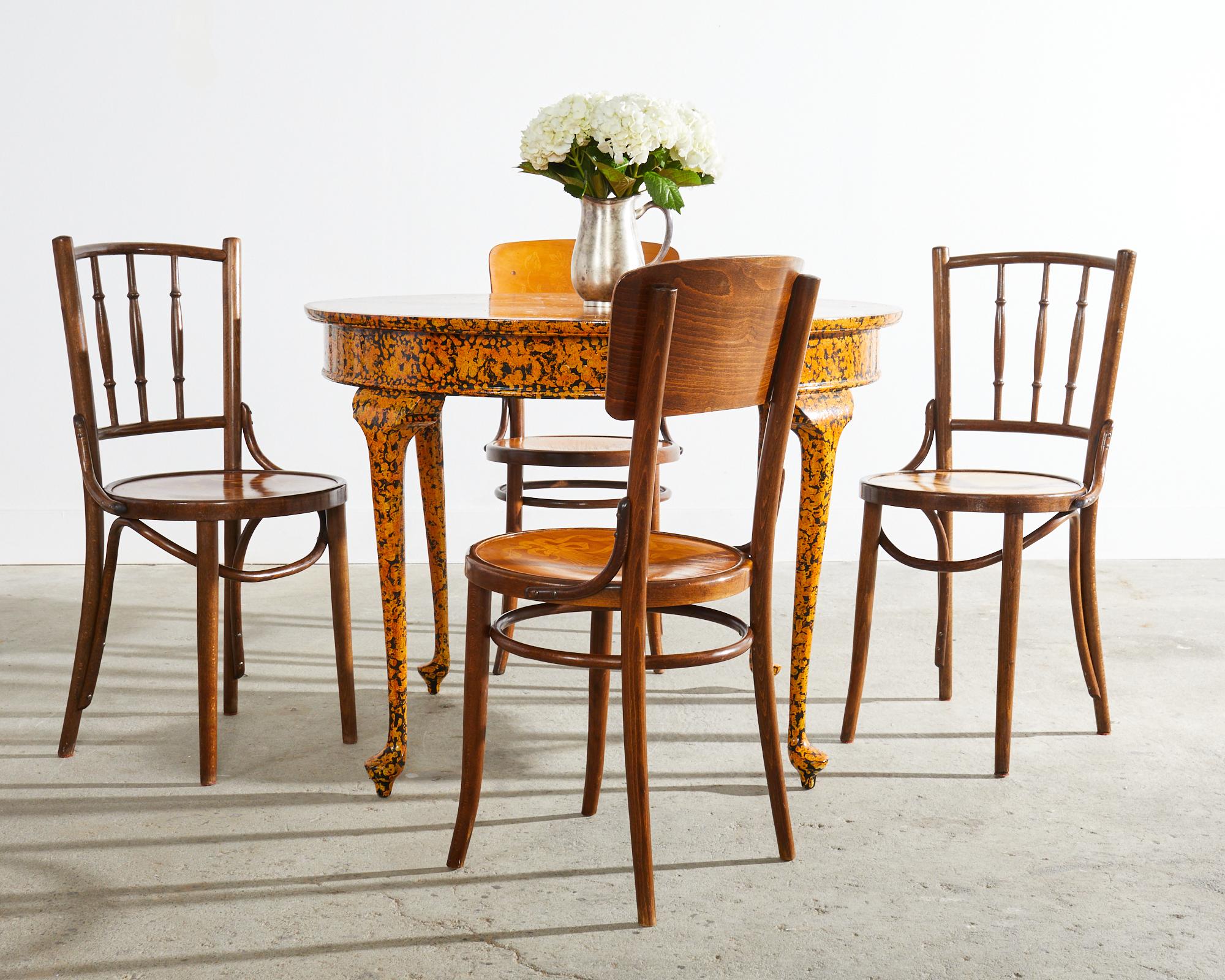 Assembled set of four art nouveau period bentwood cafe bistro dining chairs by Mundus for Thonet. Made in Czech Republic the set consists of two chairs with a spindle back and two chairs with a shaped back having a floral motif. Each chair has a