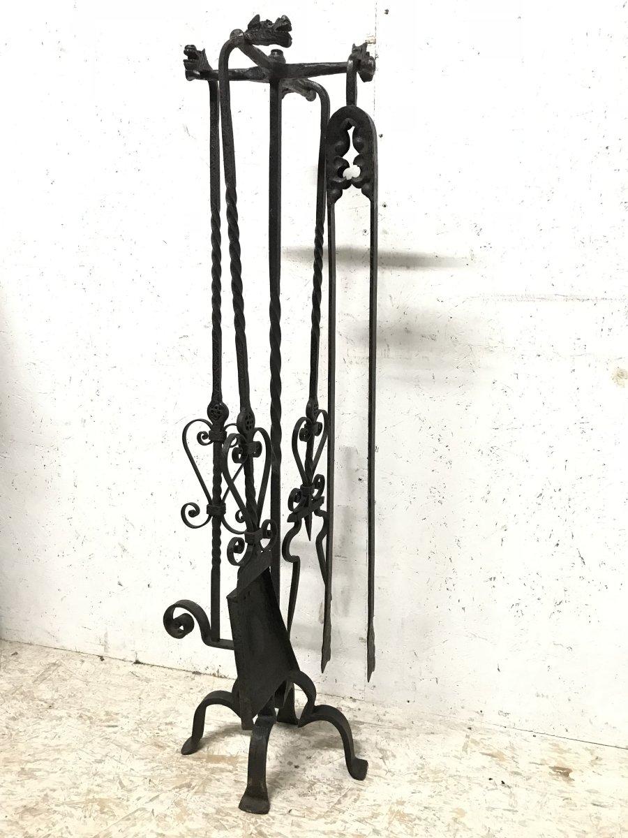 A set of four Arts & Crafts hand-forged fire utensils with stylized dogs heads and zig-zag dot and line chased details on a hand-forged iron stand.
This set of fire utensils have been lightly cleaned and waxed to preserve the original patina.
The