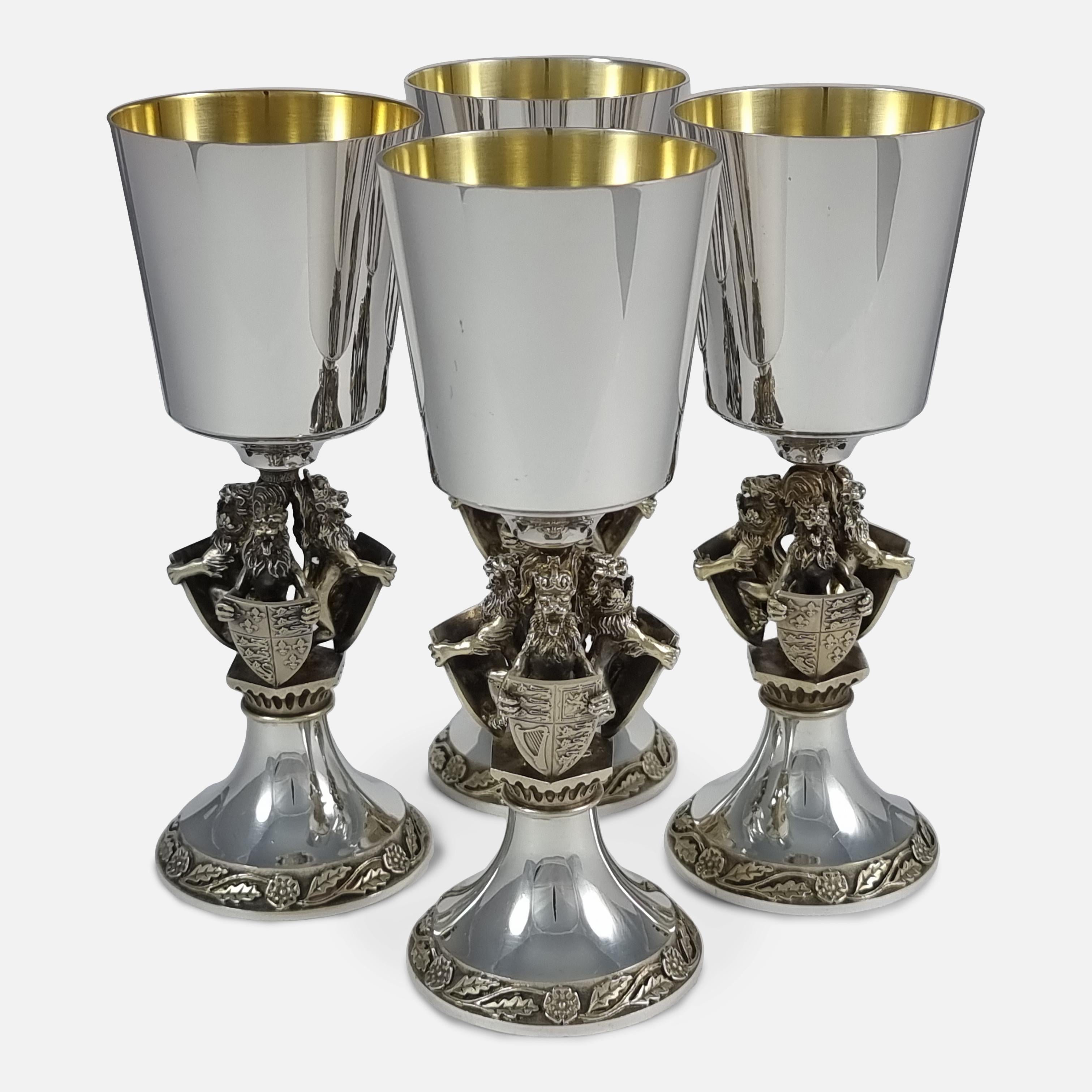 A set of four Parcel-Gilt Sterling Silver Goblets, by Hector Miller for Aurum, London, 1984. The goblets are numbered 33, 34, 36, and 364, from a limited edition of 500. The goblets are each crafted with a plain bowl above a stem with three heraldic
