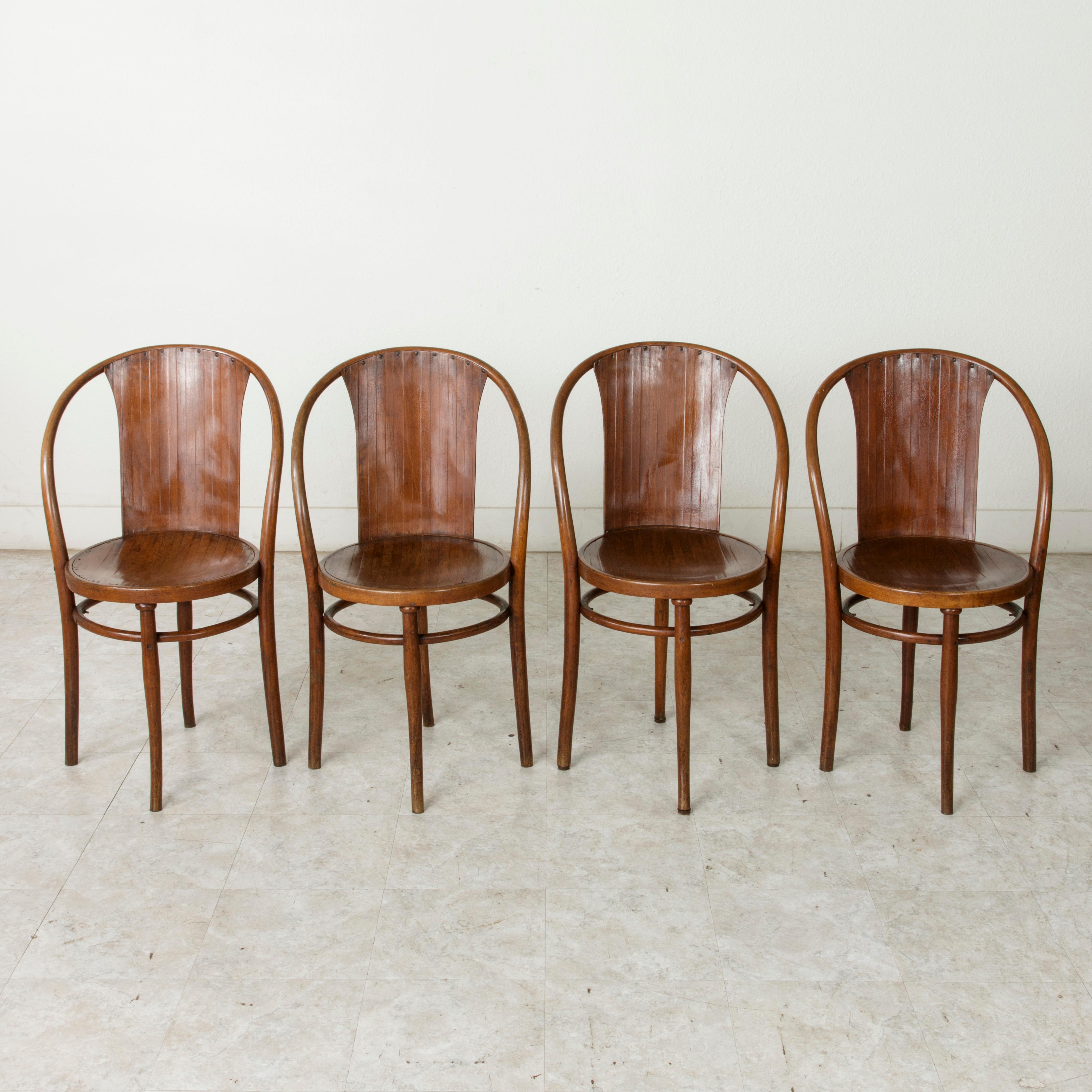 This set of four early 20th century Austrian Art Deco bentwood bistro chairs are marked Jacob and Josef Kohn on the bottoms. The Kohn father and son duo were contemporaries of designer Thonet, who also specialized in bentwood furniture. Founding