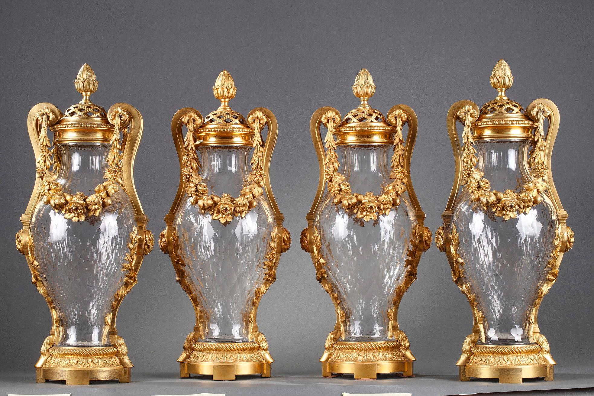 A very fine and rare set of four baluster-shaped covered vases made of faceted ovoid cut Baccarat crystal and adorned with a bronze mount of exceptional quality and kept with its original gilding. Each topped with a pierced cover surmounted by a