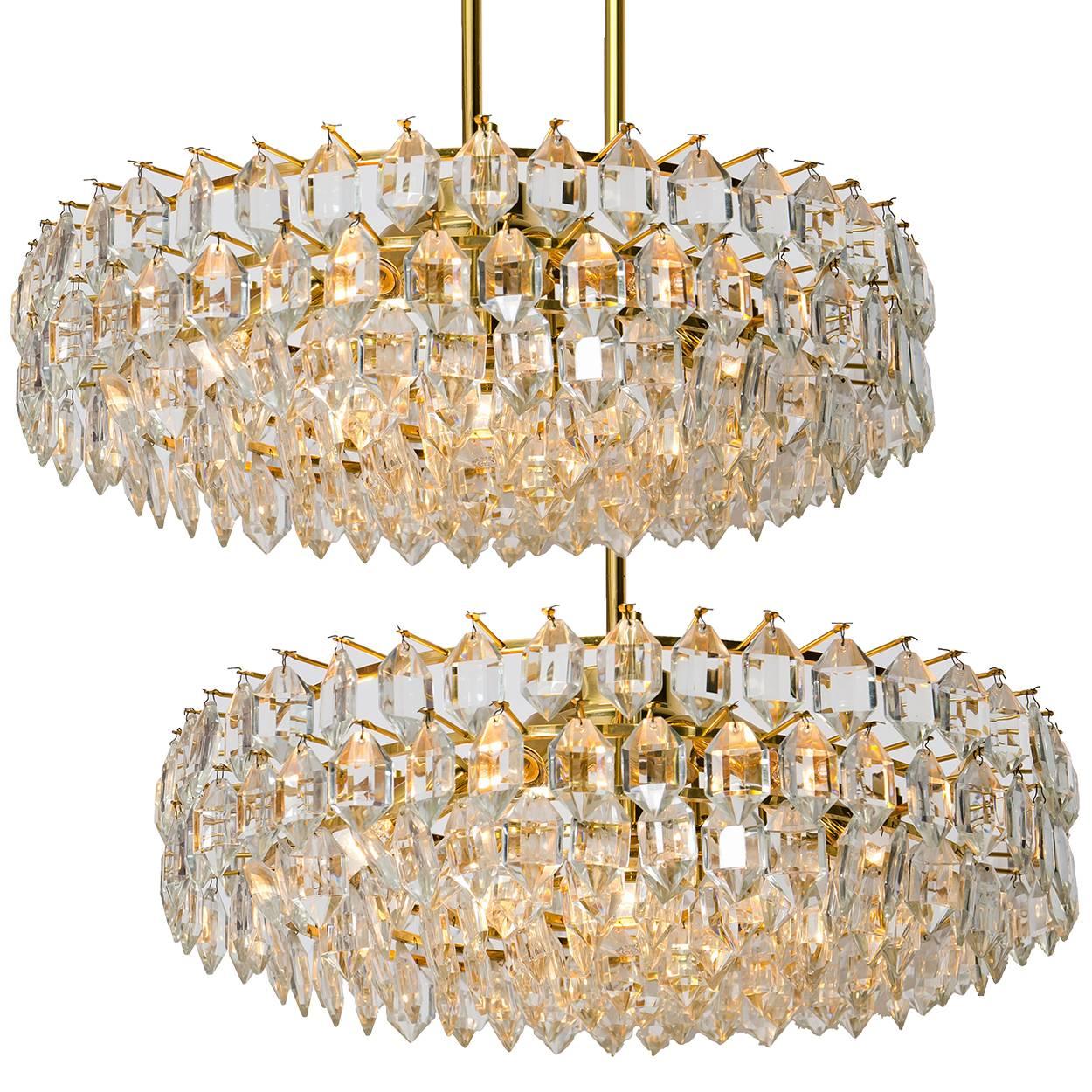 Set of very elegant light fixtures by Bakalowits and Sohne with huge gem-like crystals and brass frame. Two large chandeliers and two wall lights. The crystals are meticulously cut in such a way that radiate the light of the bulbs in different